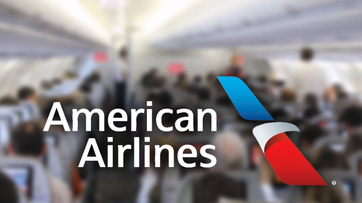 Airlines 桌布 壁紙 — 美國航空標誌顯眼地顯示在模糊的飛機客艙上，客艙內坐滿乘客。