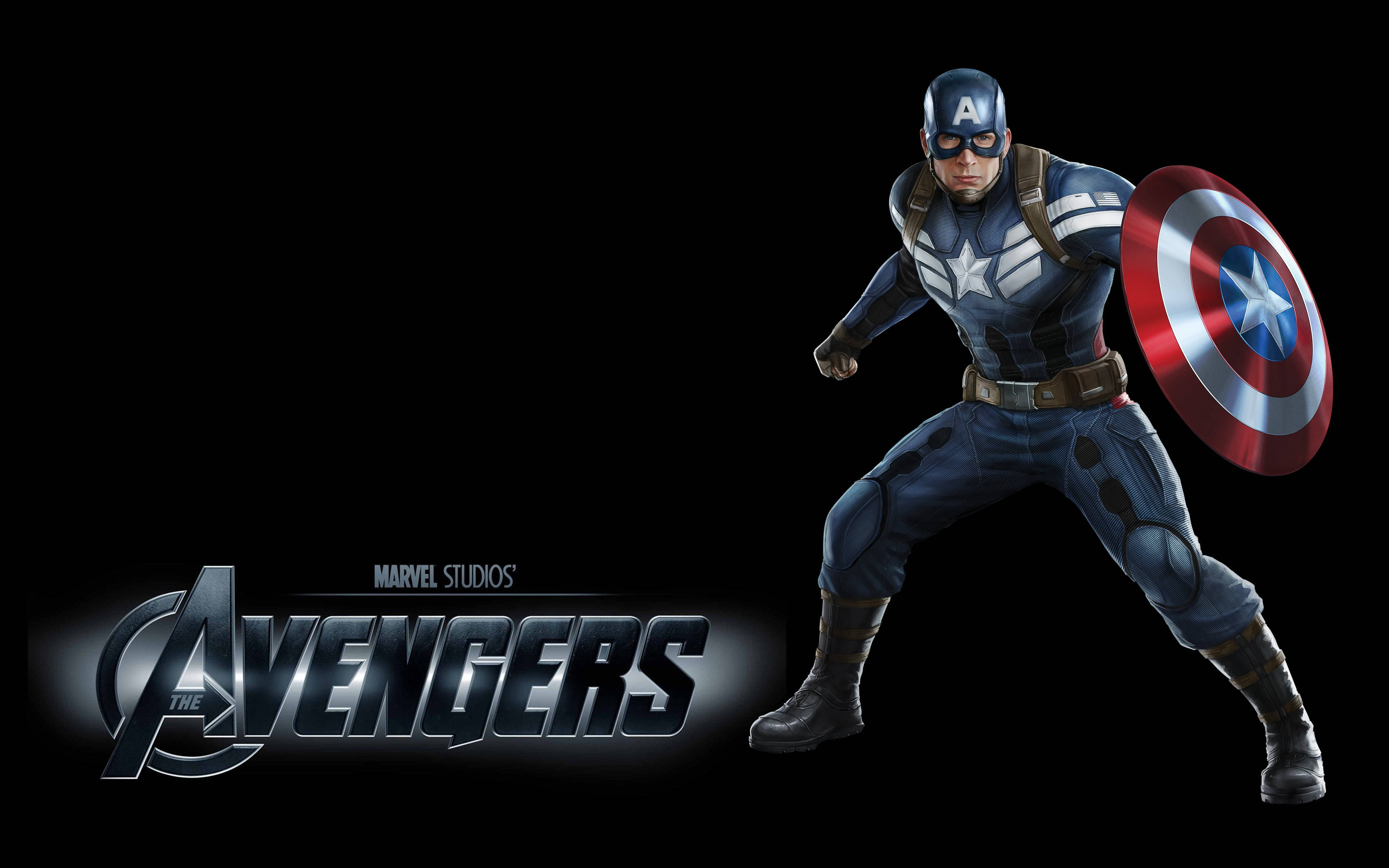 Marvel Captain America 桌布 壁紙 — 美國隊長以英雄姿態站立，手持標誌性盾牌，背景為黑色並帶有復仇者聯盟標誌。