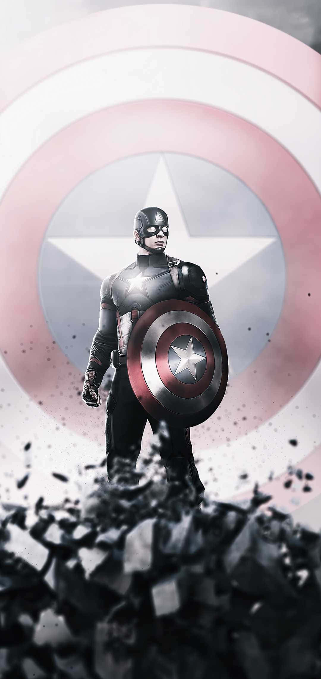 Android Captain America 桌布 壁紙 — 美國隊長挑釁地站立，手持盾牌，周圍破碎的碎片爆炸，背景是褪色的圓形徽章。