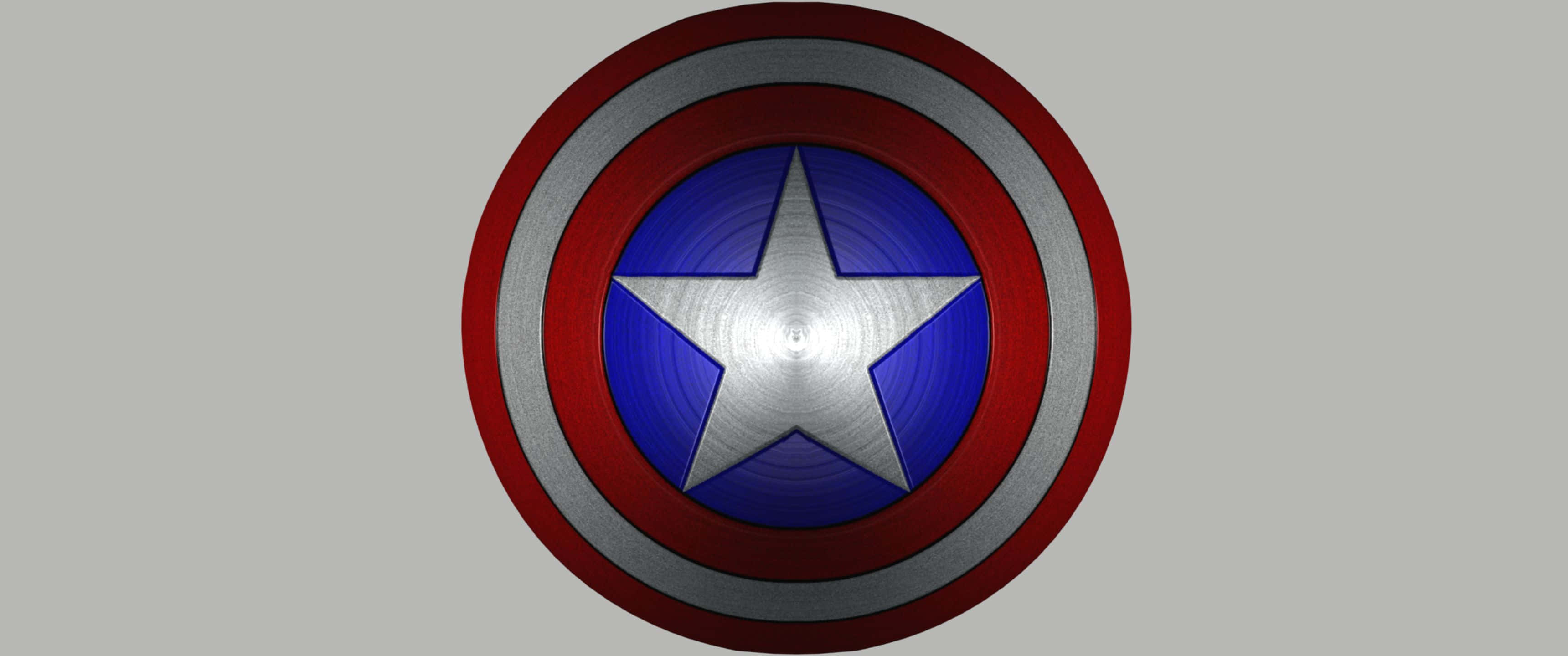 3440x1440p Captain America 桌布 壁紙 — 美國隊長標誌性圓形盾牌的特寫，帶有紅、白、藍同心圓環和銀色星星，居中於灰色背景上。