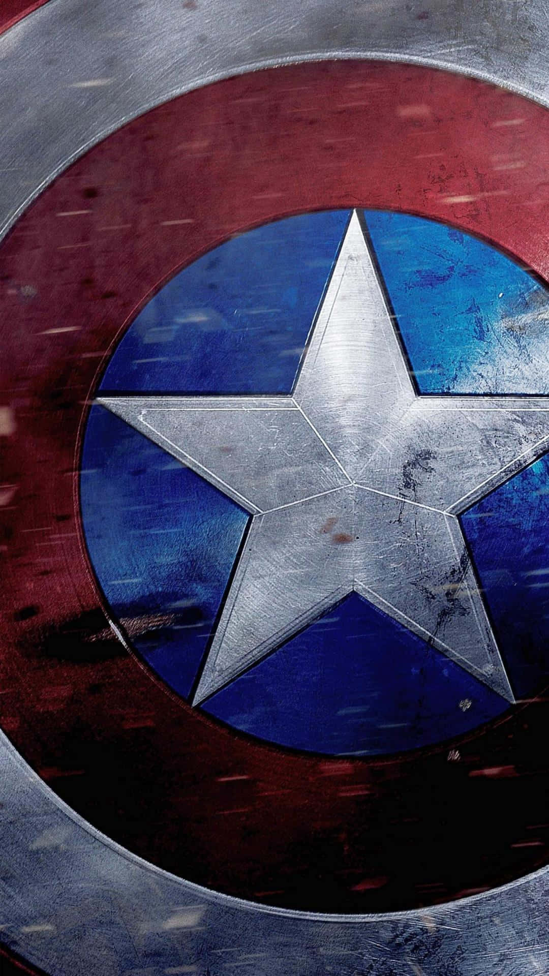 Captain America Logo 桌布 壁紙 — 美國隊長標誌性盾牌的特寫，顯示磨損的紅色、藍色和銀色金屬，中間有一顆星。