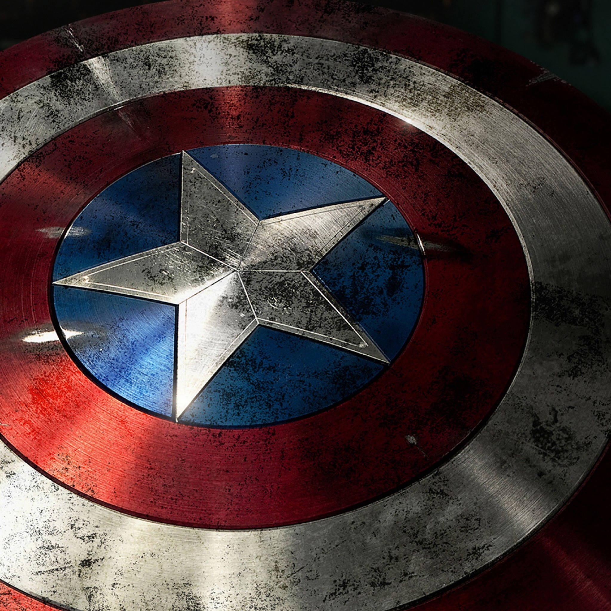 Captain America iPhone 桌布 壁紙 — 美國隊長標誌性盾牌的特寫，顯示經過戰鬥磨損的紅、白、藍色金屬，中央有一顆星。