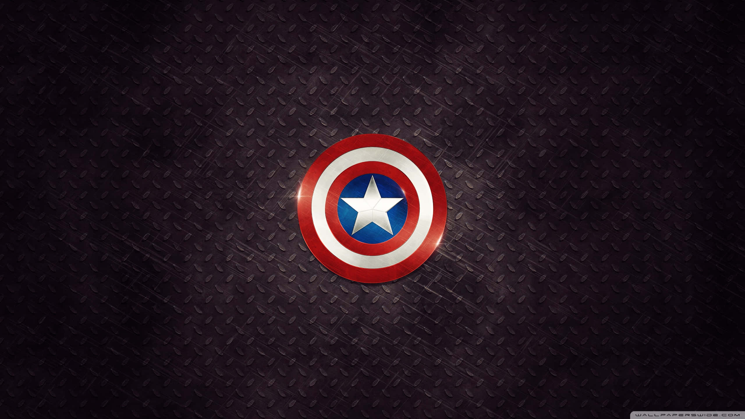 Captain America Desktop 桌布 壁紙 — 美國隊長的標誌性盾牌在深色紋理菱形板背景上閃耀著金屬光澤。
