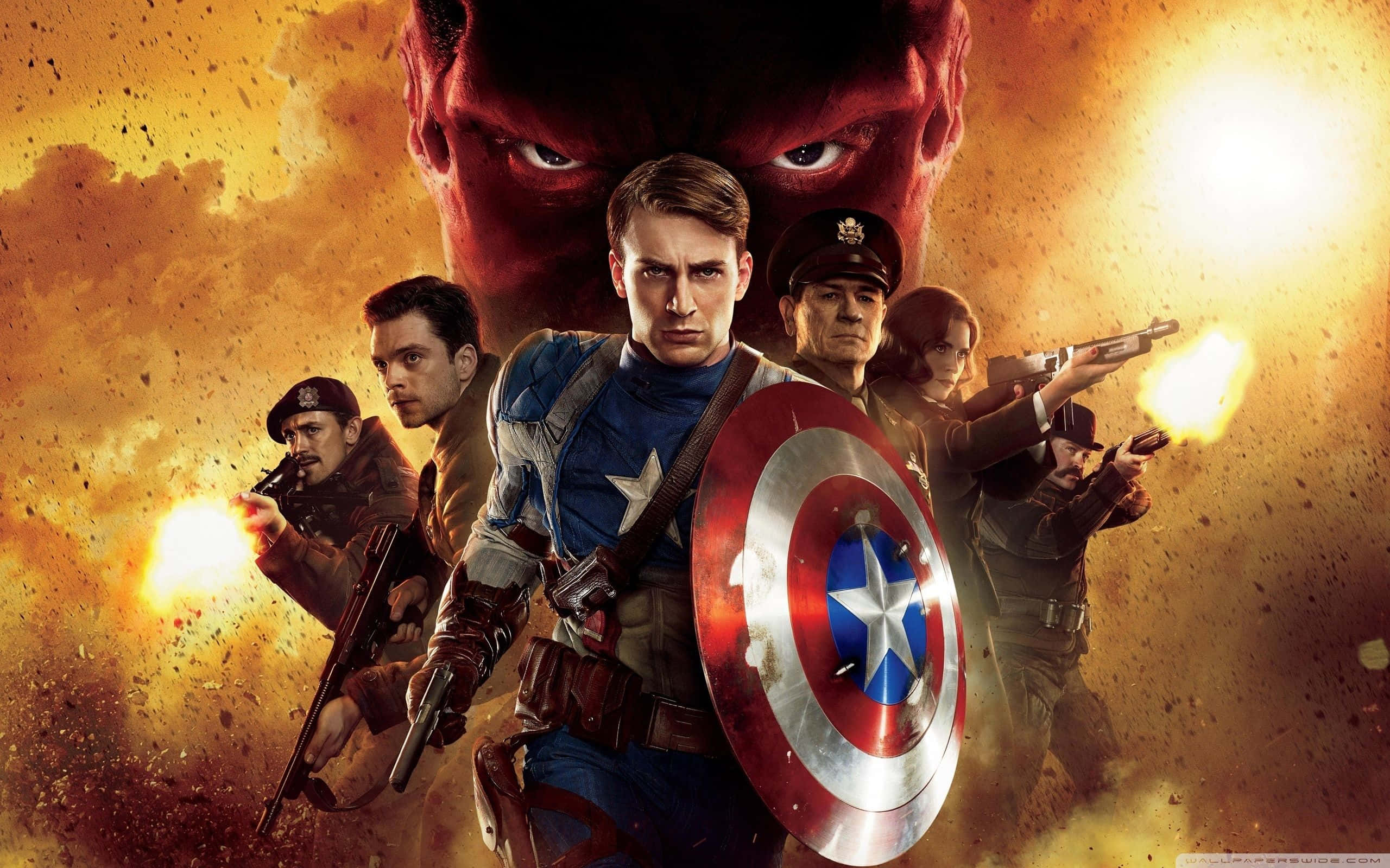 Captain America Movie 桌布 壁紙 — 美國隊長與盟友在熾熱的戰鬥中準備就緒，對抗一個眼睛發光的紅色反派。