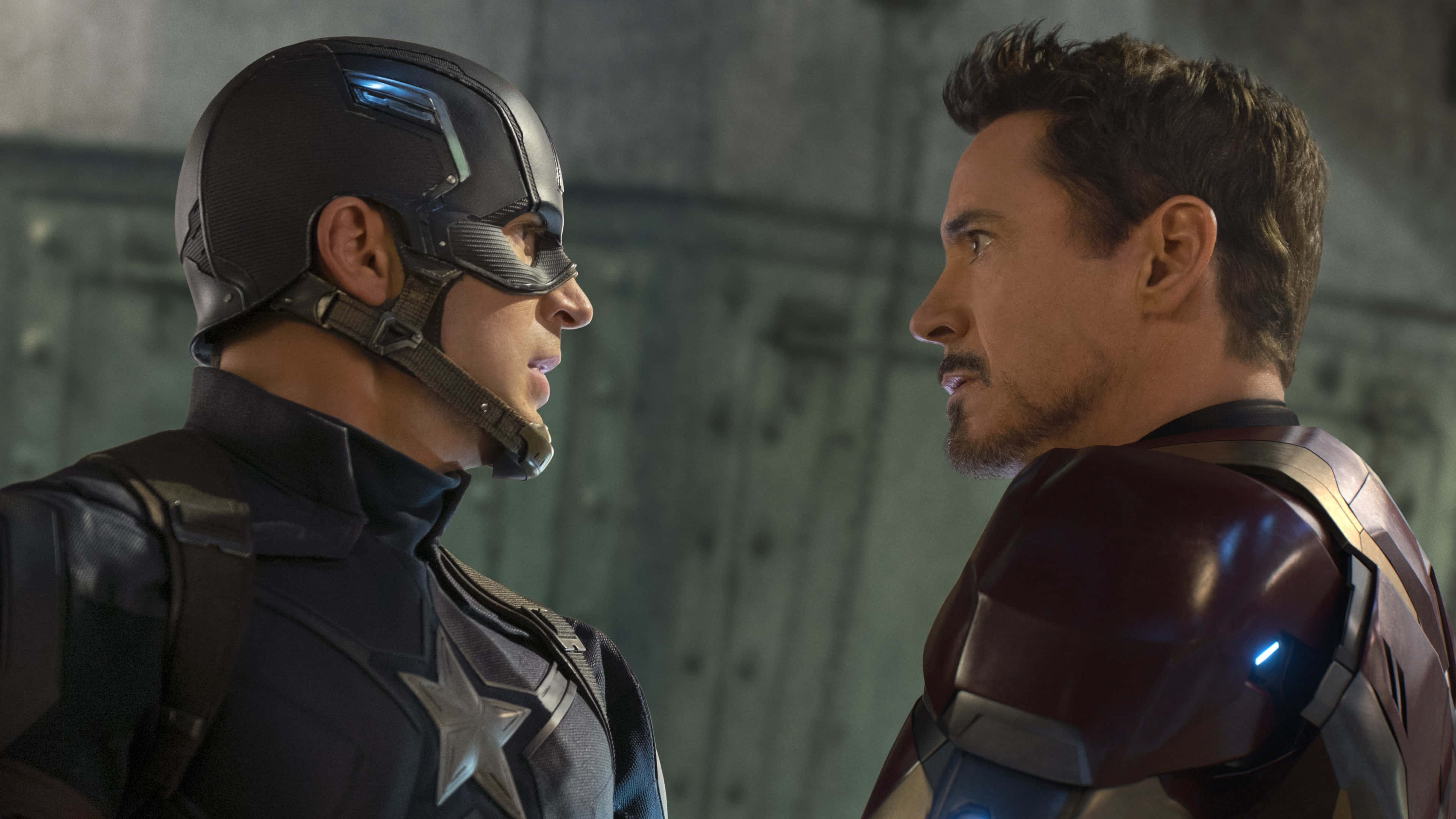 Captain America Movie 桌布 壁紙 — 美國隊長與鋼鐵人在骯髒的工業設施內緊張對峙。