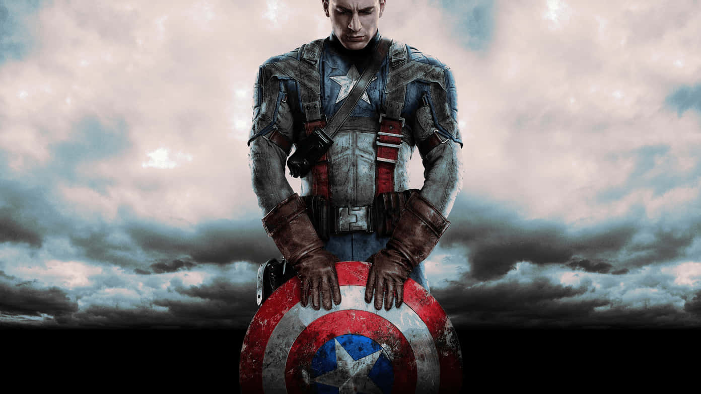 Best Marvel 桌布 壁紙 — 美國隊長莊嚴地舉著盾牌，背景是風暴般的灰色天空和戲劇性的雲層。