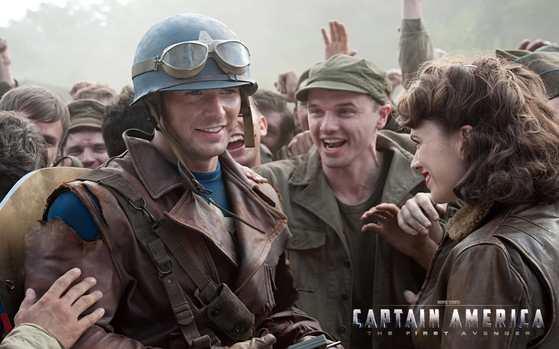 Captain America Movie 桌布 壁紙 — 美國隊長身穿復古軍裝，溫暖地微笑，周圍一群歡樂的士兵和平民為他歡呼。