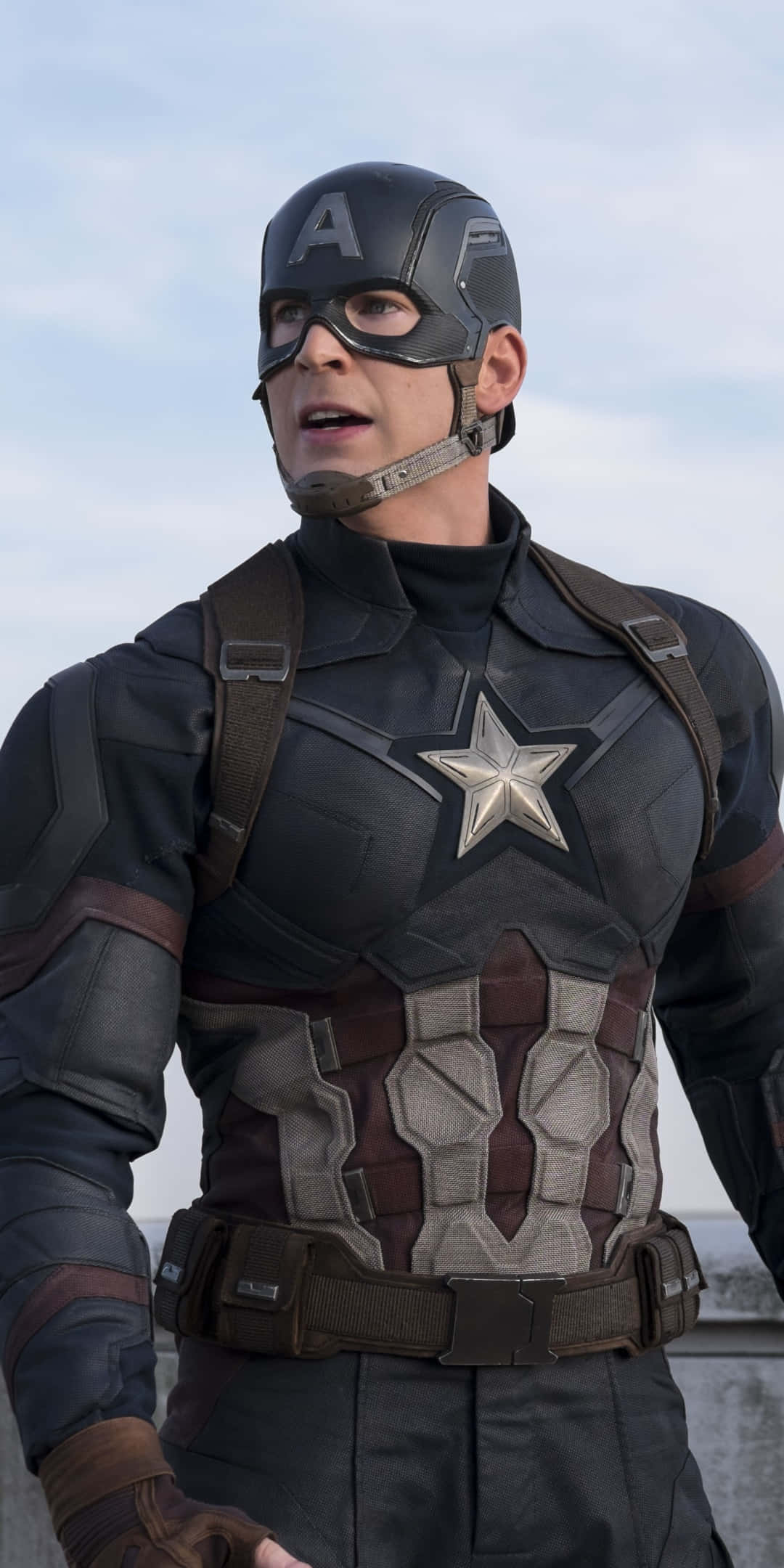 Captain America Movie 桌布 壁紙 — 美國隊長身穿戰術裝備，帶有星星標誌，背景是陰天。