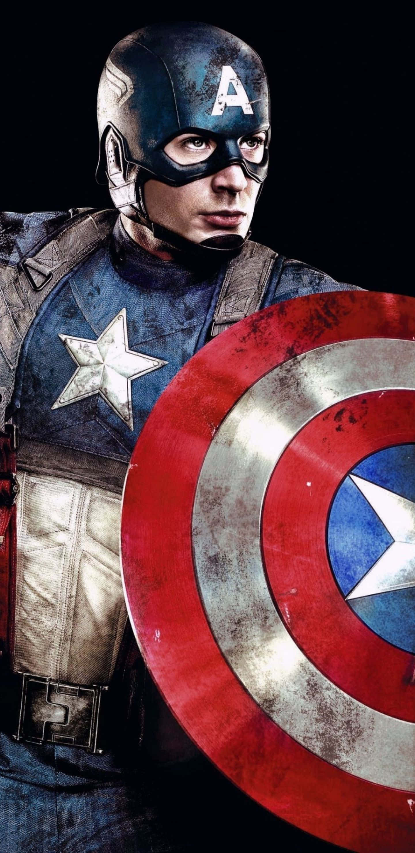 Pixel 3xl Captain America 桌布 壁紙 — 美國隊長身穿戰鬥裝備，在黑暗背景下堅定地手持標誌性盾牌。