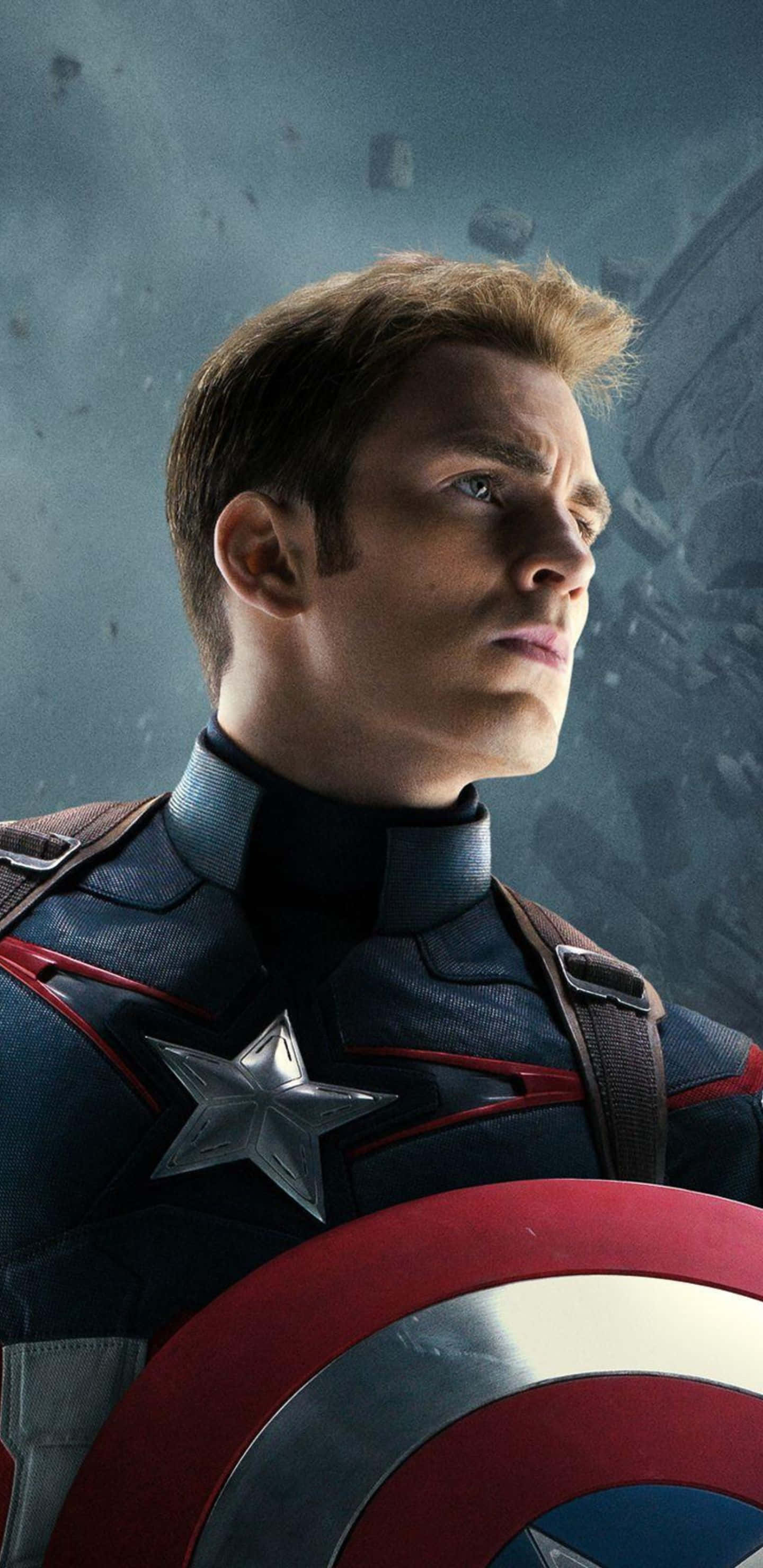 Pixel 3xl Captain America 桌布 壁紙 — 美國隊長身穿標誌性的藍、紅、白色戰衣，手持星條盾牌，在風暴肆虐的戰場背景下堅定站立。