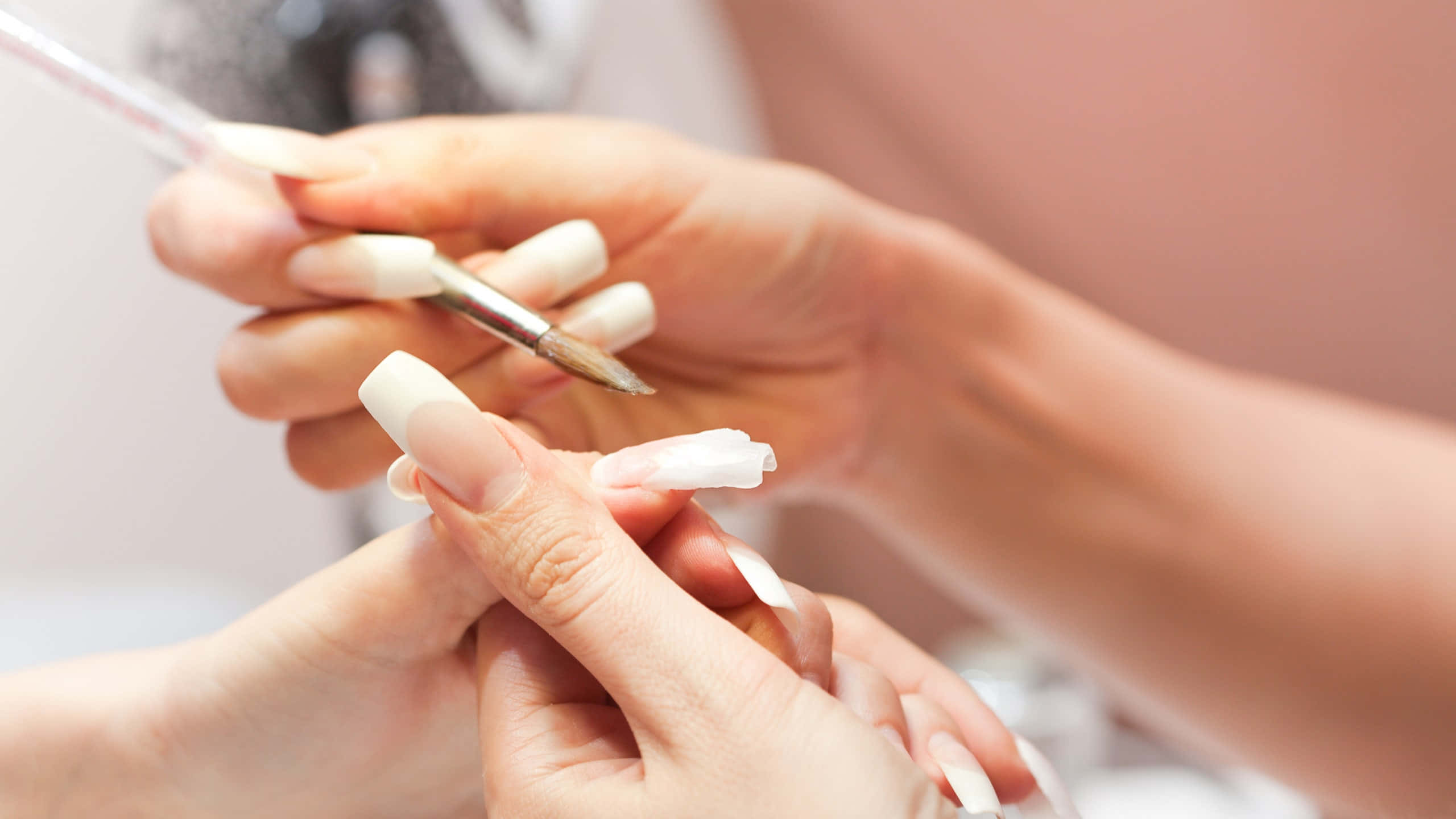 Manicure 桌布 壁紙 — 美甲師用細刷為客戶的長白色水晶甲塗上透明面油的近距離特寫。