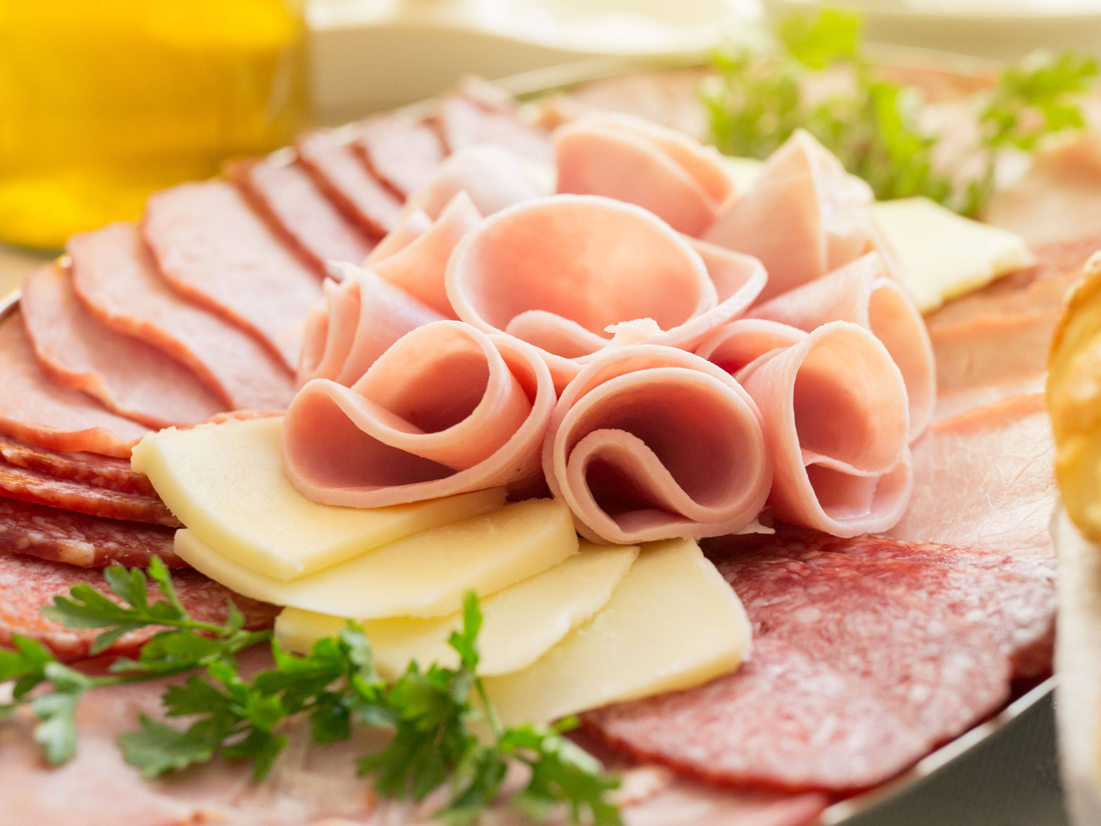 Ham 桌布 壁紙 — 美食熟食拼盤的特寫，包含捲起的火腿玫瑰、切片起司、莎樂美腸和新鮮歐芹裝飾。