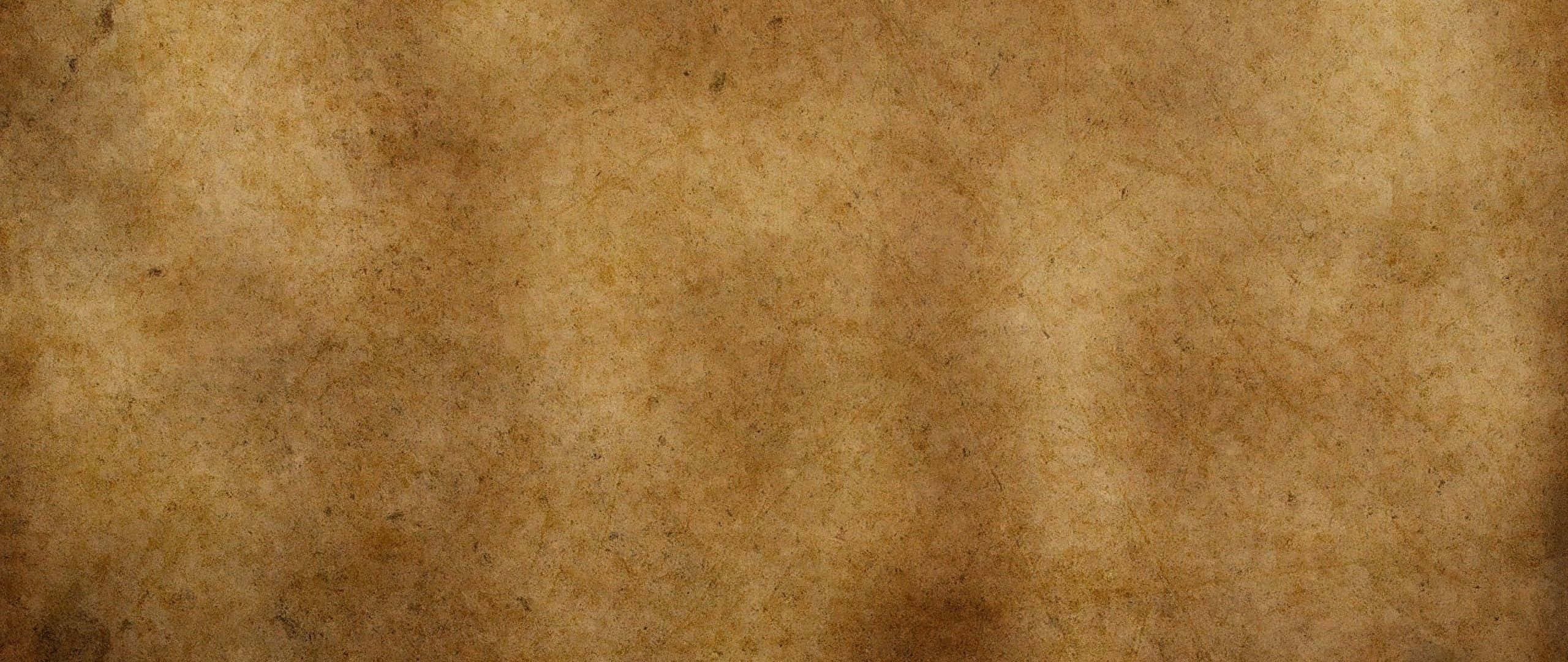 Panoramic 桌布 壁紙 — 老化羊皮紙的特寫，帶有不均勻的棕色色調和微妙的紋理變化。