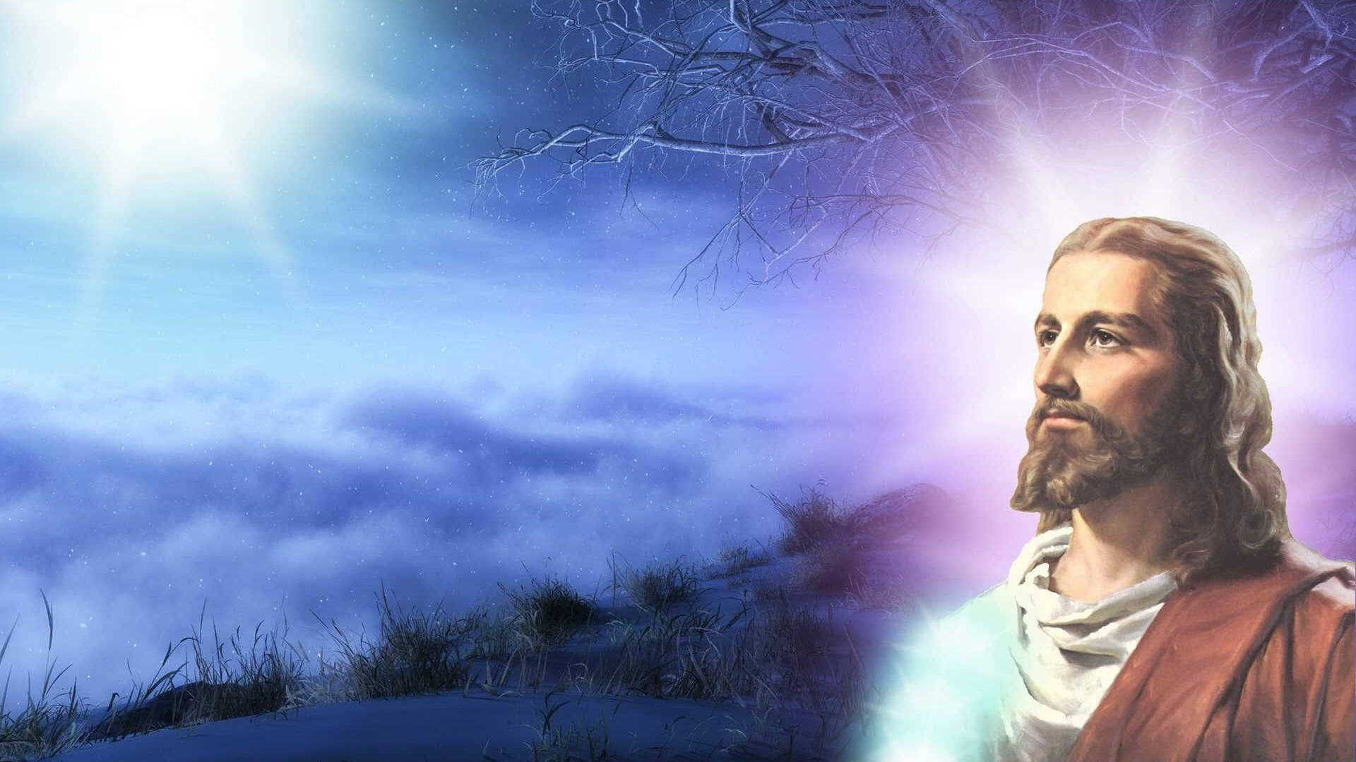 高清 桌布 壁紙 — 耶穌基督寧靜地站在白雪覆蓋的山丘上，沐浴在燦爛的天光中，下方是光禿的冬季樹木和雲層。