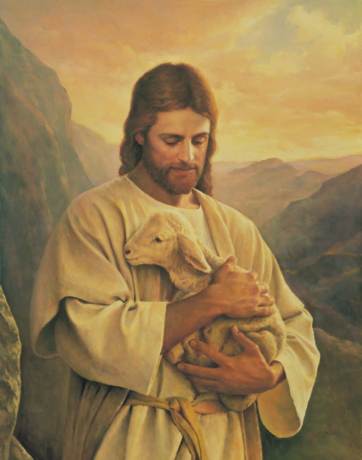 Jesus With Sheep 桌布 壁紙 — 耶穌溫柔地懷抱一隻羔羊，背景是遠山之上溫暖的金色日落，一幅寧靜的宗教畫作。