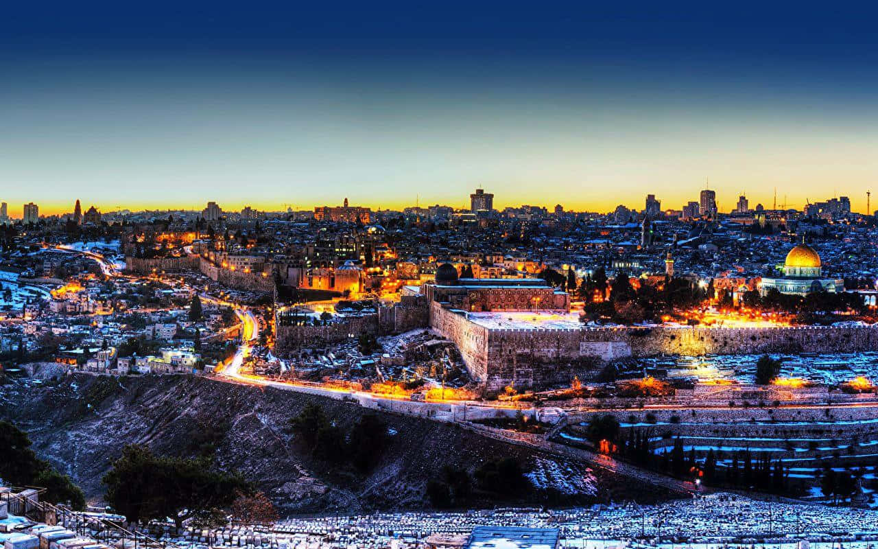 Israel 桌布 壁紙 — 耶路撒冷歷史天際線的壯麗暮色景觀，金色圓頂和古老城牆在深藍色天空下閃耀。