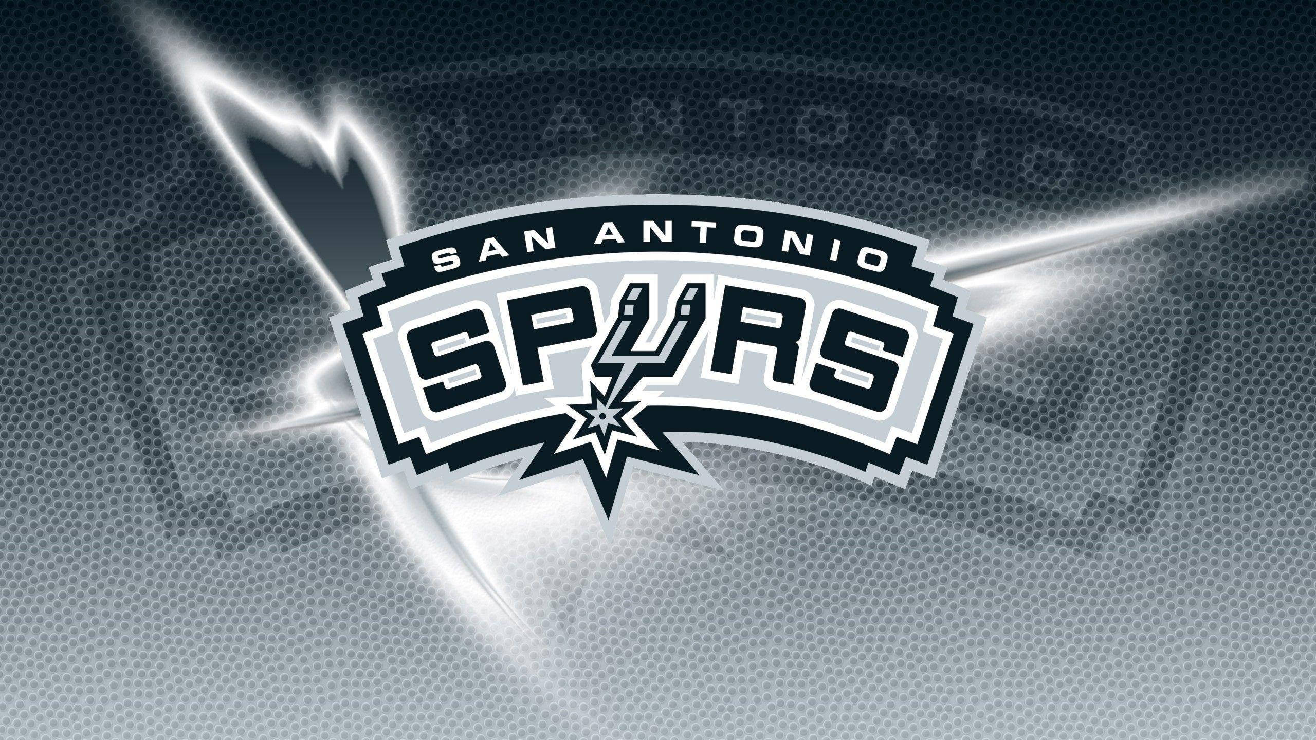 Spurs 桌布 壁紙 — 聖安東尼奧馬刺隊標誌在帶有紋理的深藍色籃球背景上閃耀著銀色光條。