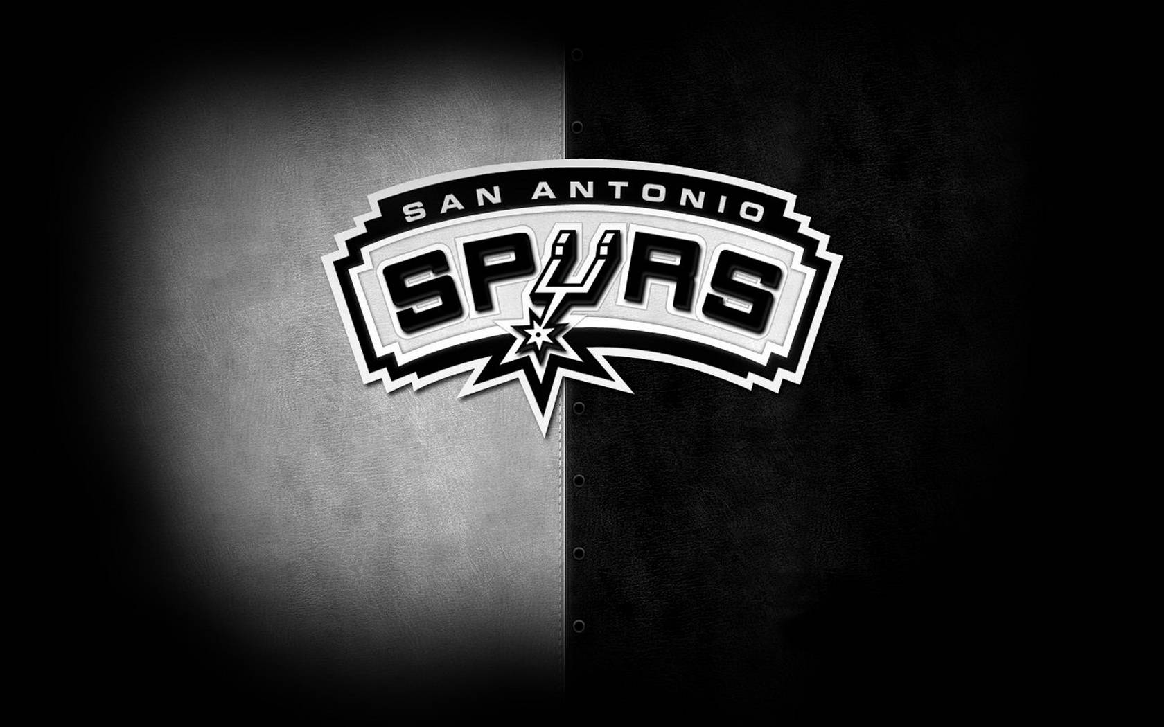 Spurs 桌布 壁紙 — 聖安東尼奧馬刺隊標誌居中於一個分開的黑色和灰色紋理背景上，帶有聚光燈效果。