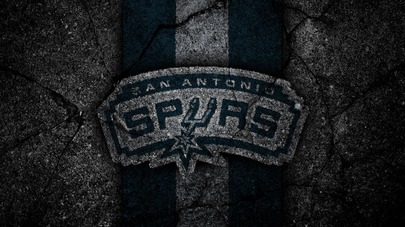 Spurs 桌布 壁紙 — 聖安東尼奧馬刺隊標誌蝕刻在帶有藍色和灰色條紋的裂開深色混凝土上。