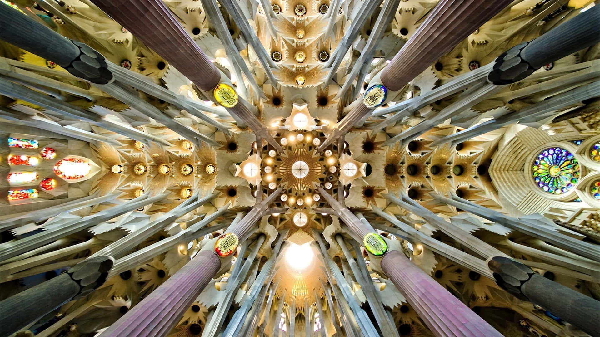 Barcelona 桌布 壁紙 — 聖家堂內部令人驚嘆的向上景觀，複雜的柱子向發光的中央吊燈輻射。
