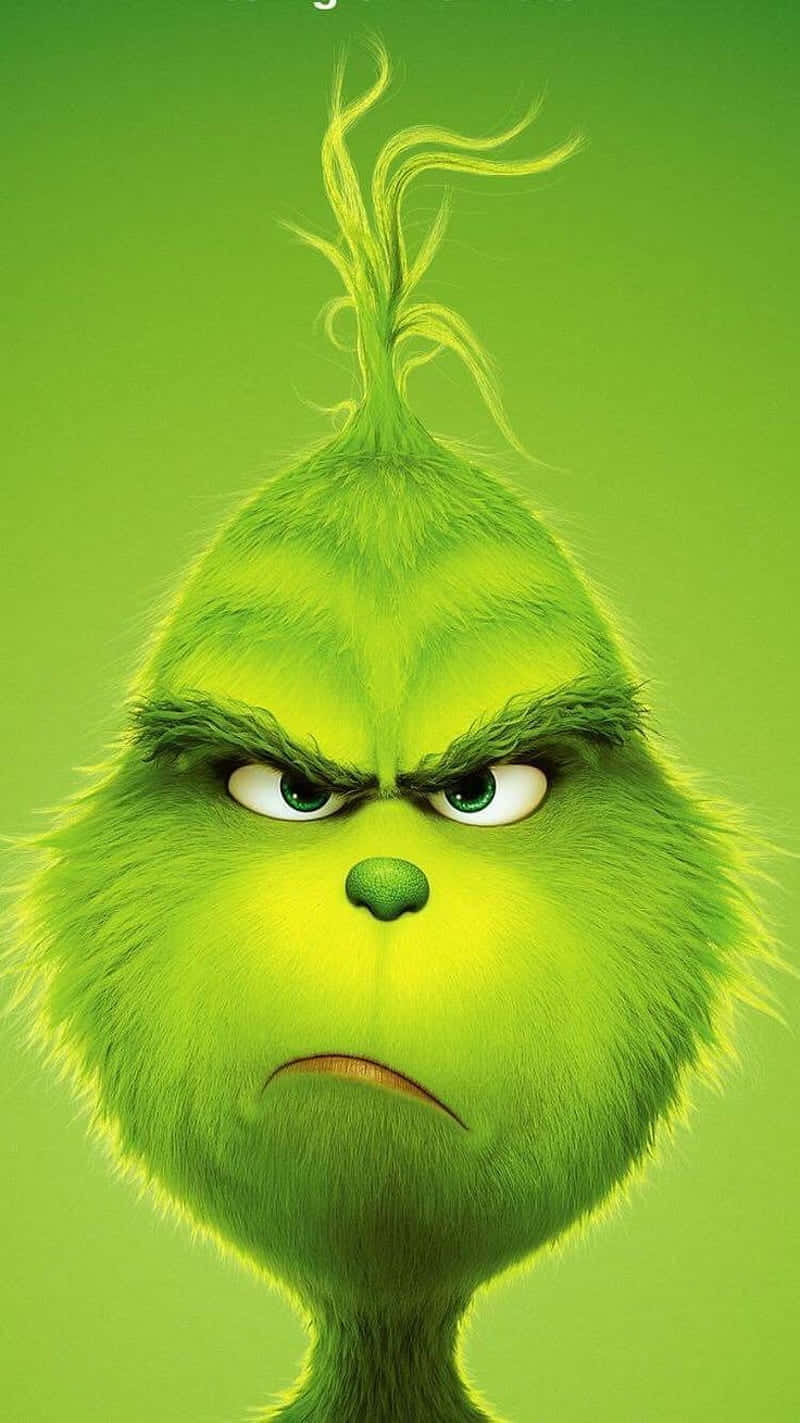 鬼靈精 桌布 壁紙 — 聖誕怪傑 Grinch 綠色繃緊面孔的特寫，眉頭緊鎖，一臉不悅，背景為純綠色。