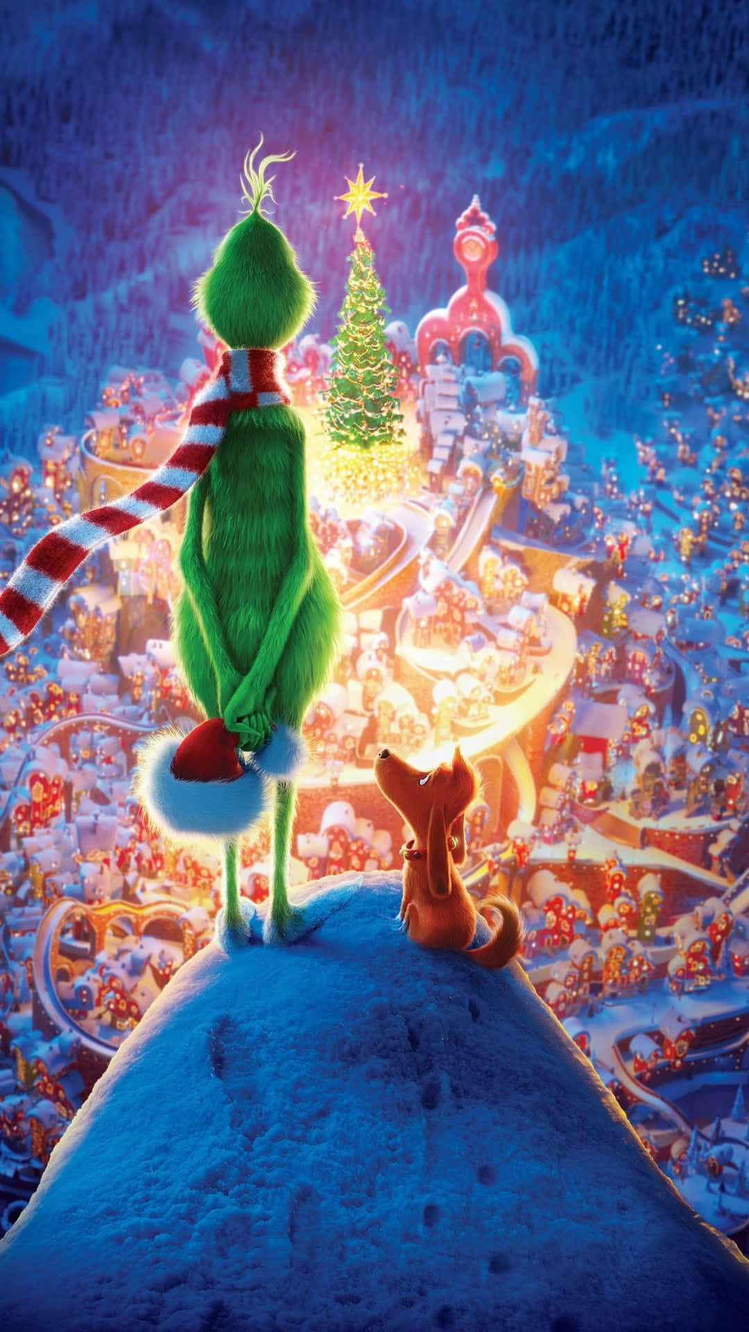 Christmas Movie 桌布 壁紙 — 聖誕怪傑格林奇和麥克斯俯瞰著一個閃閃發光的雪城，裝飾著節日燈飾和一棵巨大的聖誕樹，在星空下。