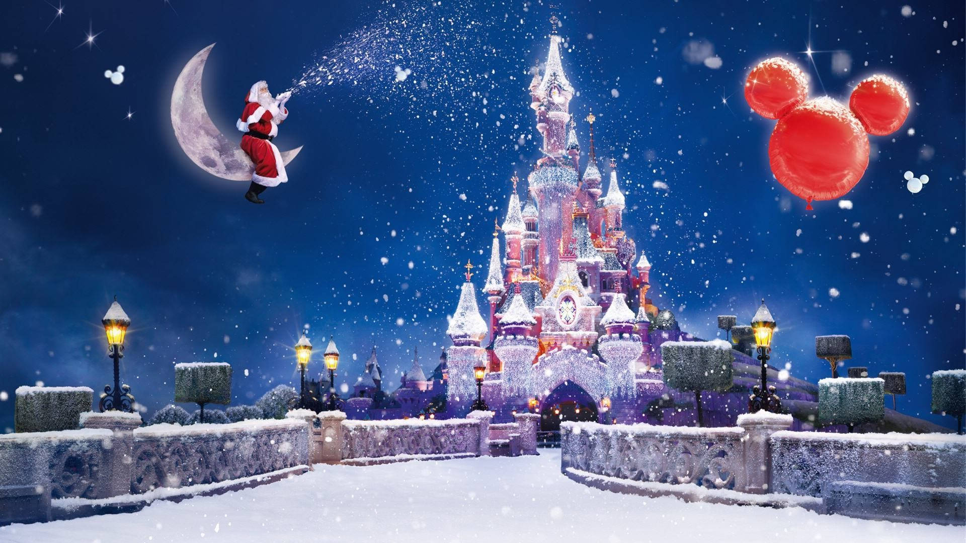 Santa Claus 桌布 壁紙 — 聖誕老人從新月灑下魔法，在滿天星斗的夜空下，覆蓋著雪的迪士尼城堡上方，有米奇氣球飄浮。