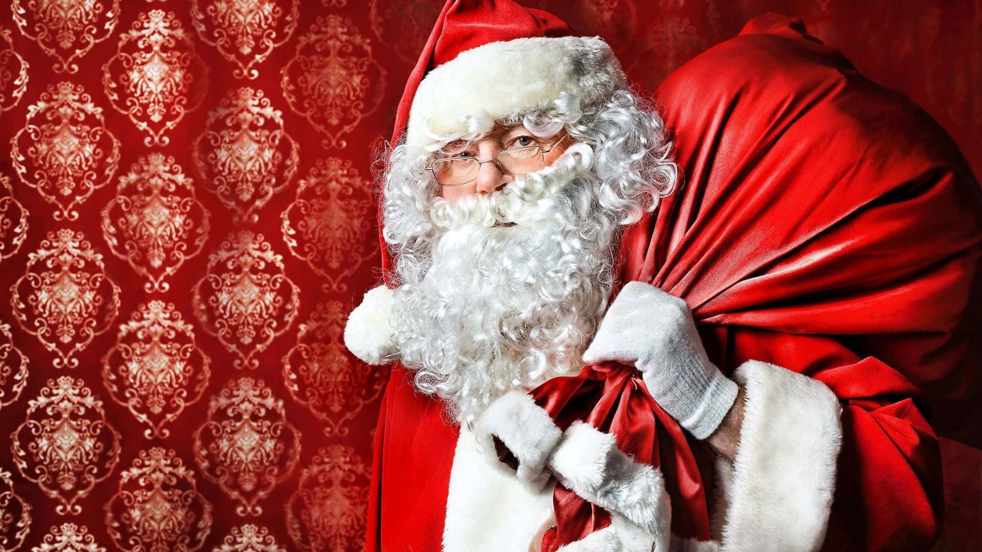 Santa Claus 桌布 壁紙 — 聖誕老人留著白鬍鬚、戴著眼鏡，手持紅色布袋，背景是華麗的紅色壁紙。
