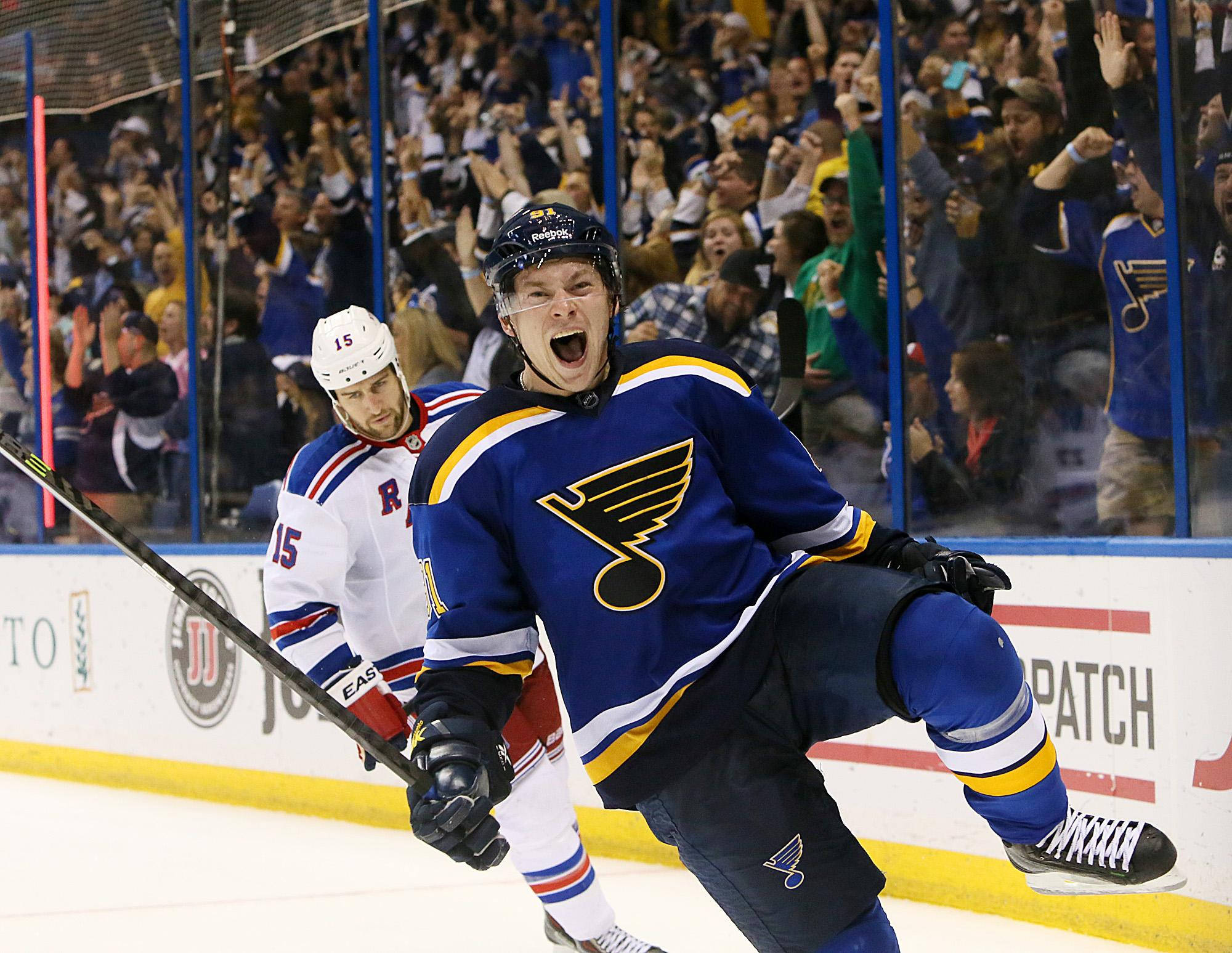 St Louis Blues 桌布 壁紙 — 聖路易斯藍調冰球球員在冰上勝利吶喊，球迷在玻璃後瘋狂歡呼。