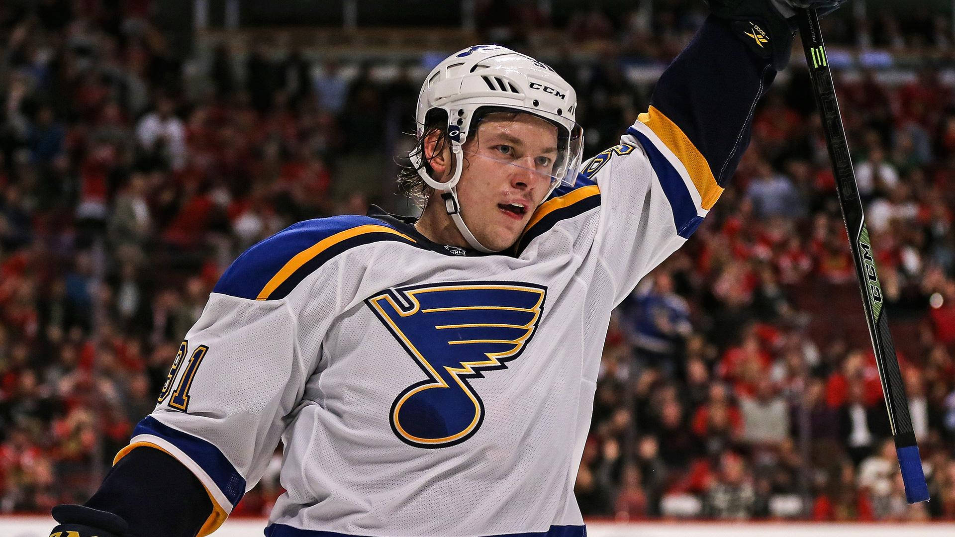 St Louis Blues 桌布 壁紙 — 聖路易斯藍調冰球球員在擠滿觀眾的場館中高舉球棍慶祝進球。