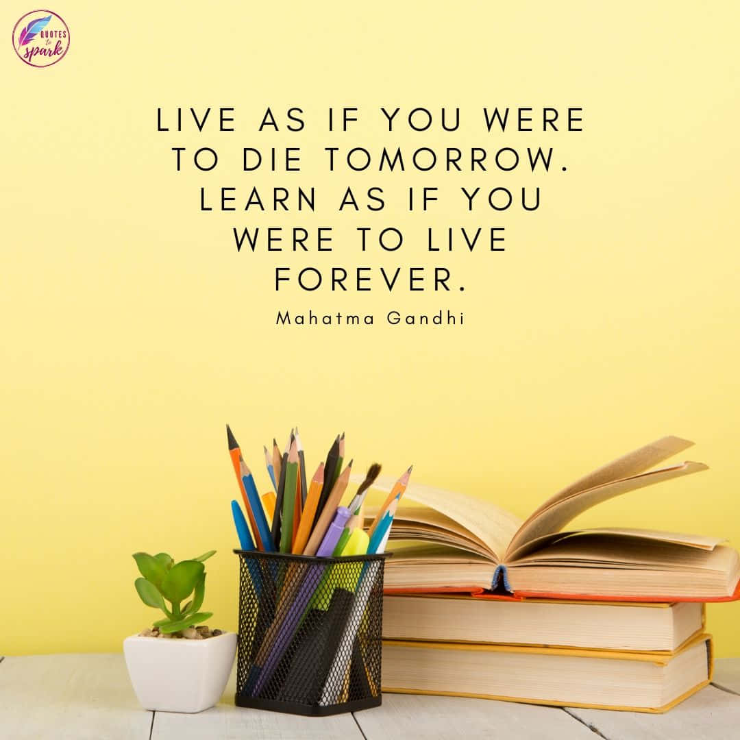 Inspirational Quotes 桌布 壁紙 — 聖雄甘地的一句勵志名言展示在一疊打開的書本、彩色鉛筆和一個小盆栽多肉植物上方，木質表面上，背景是柔和的黃色牆壁。