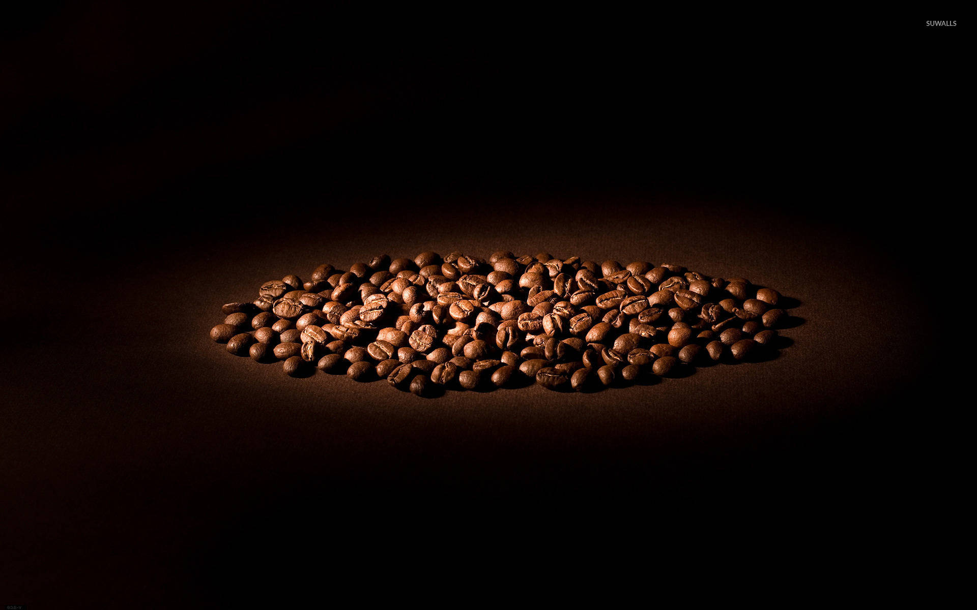 beans 桌布 壁紙 — 聚光燈照亮一堆烘焙咖啡豆，背景為深黑色。