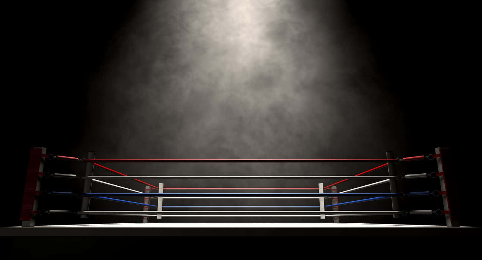 運動 桌布 壁紙 — 聚光燈照亮了黑暗背景下的迷霧拳擊擂台，投射出戲劇性的陰影，並突出了繩索和帆布。