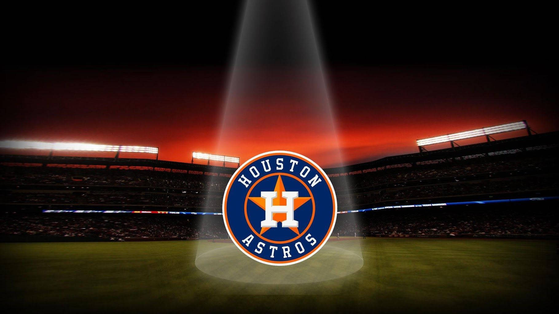 Astros 桌布 壁紙 — 聚光燈照射在休士頓太空人隊標誌上，該標誌位於暮色中的棒球場中央，體育場燈光閃爍。