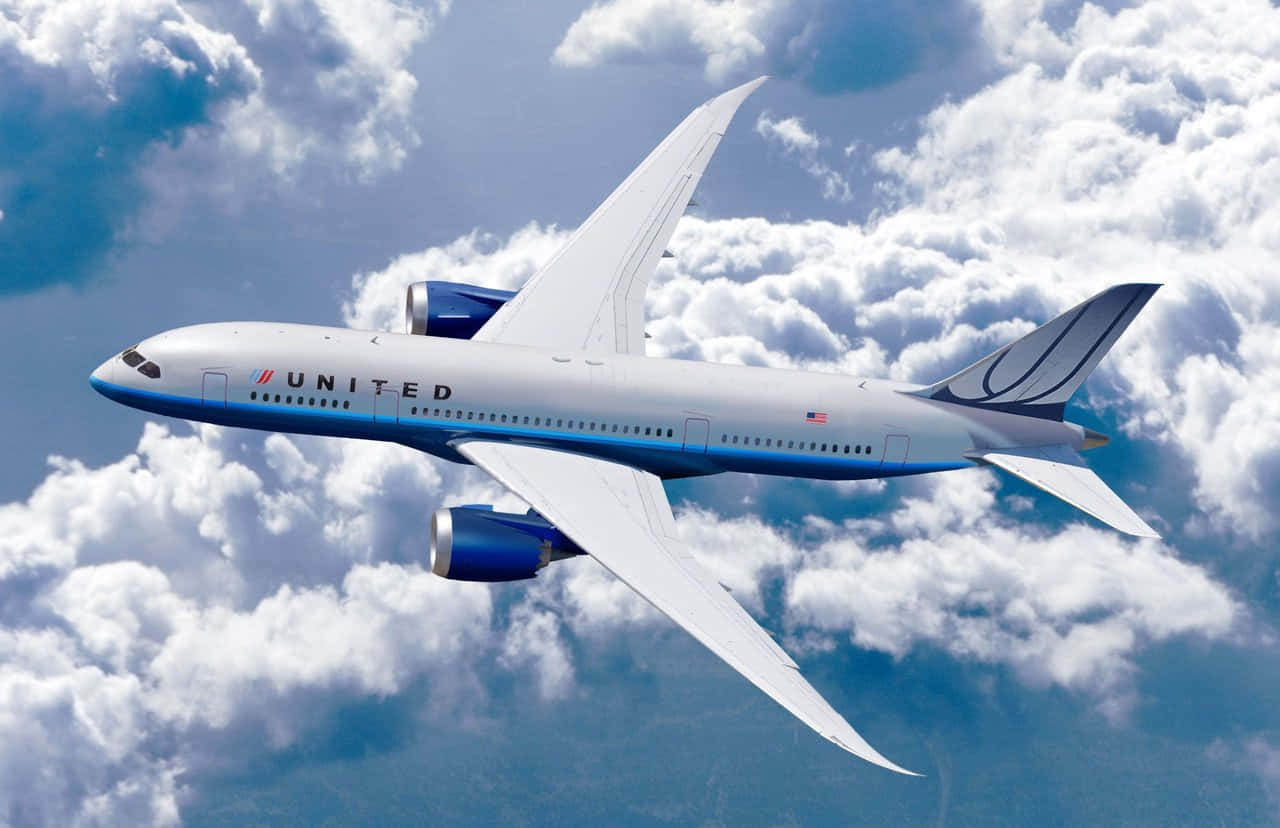 飛機 桌布 壁紙 — 聯合航空的波音787夢幻客機在鮮豔的藍天背景下，優雅地翱翔於蓬鬆的白雲之上。
