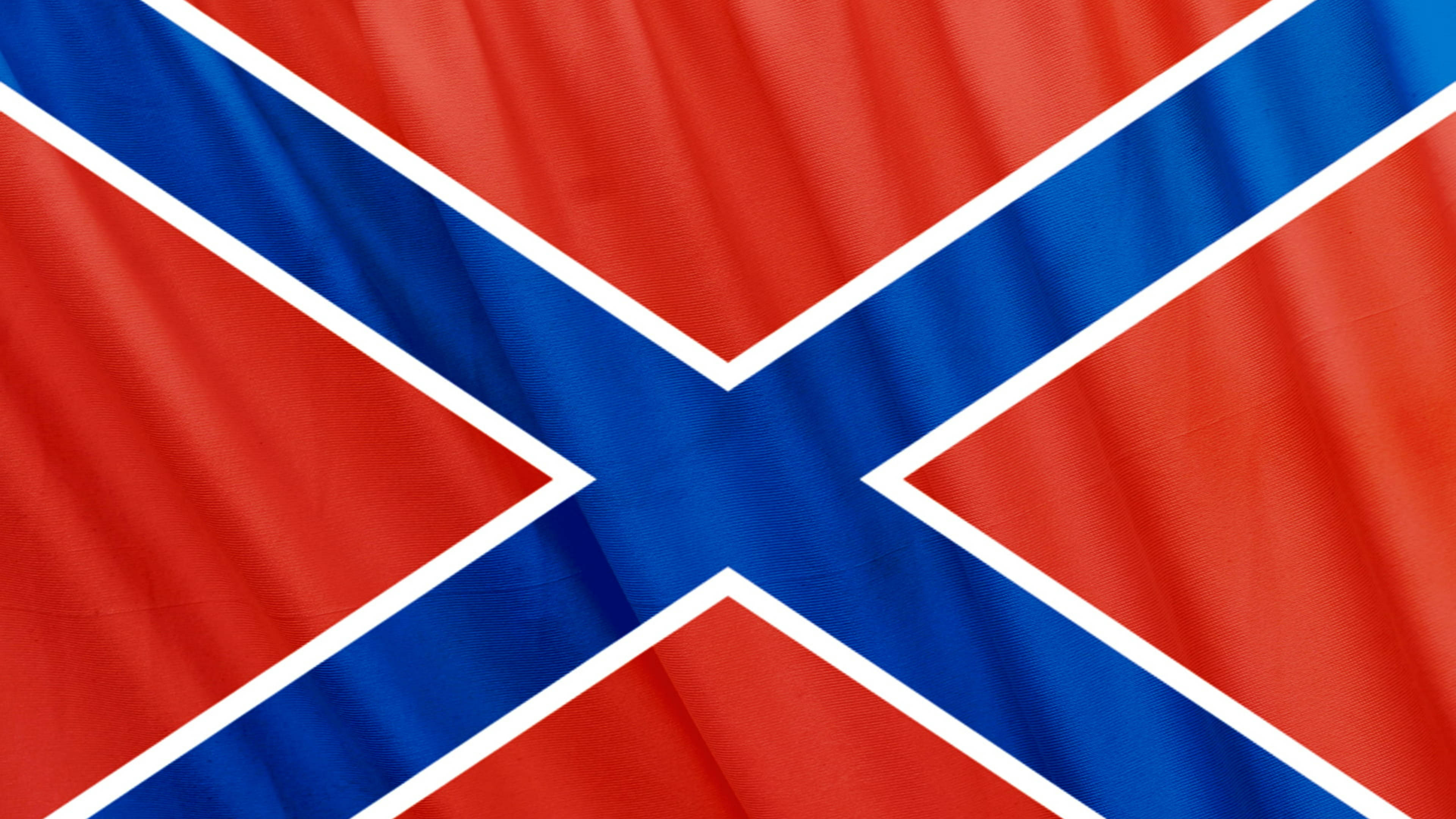 Confederate Flag 桌布 壁紙 — 聯邦旗幟布料的特寫，帶有紅色、藍色和白色條紋，在風中飄揚。