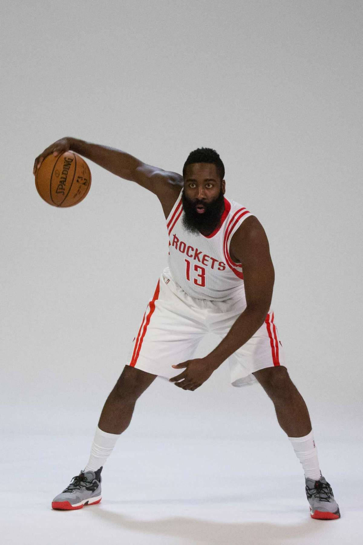 James Harden 桌布 壁紙 — 職業籃球運動員身穿白色火箭隊球衣，在純白色背景前運球（Spalding 籃球）。