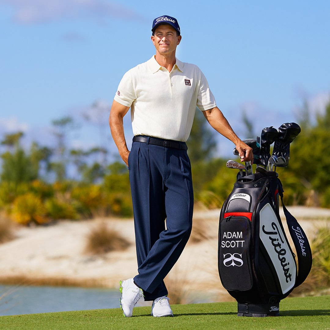 adam scott 桌布 壁紙 — 職業高爾夫球手Adam Scott自信地站在陽光明媚的高爾夫球場上，手持他的品牌Titleist球袋。