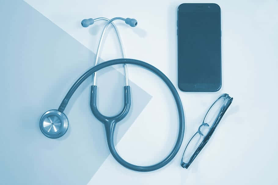 Nurse 桌布 壁紙 — 聽診器、智慧型手機和眼鏡整齊地排列在冷色調的幾何表面上。