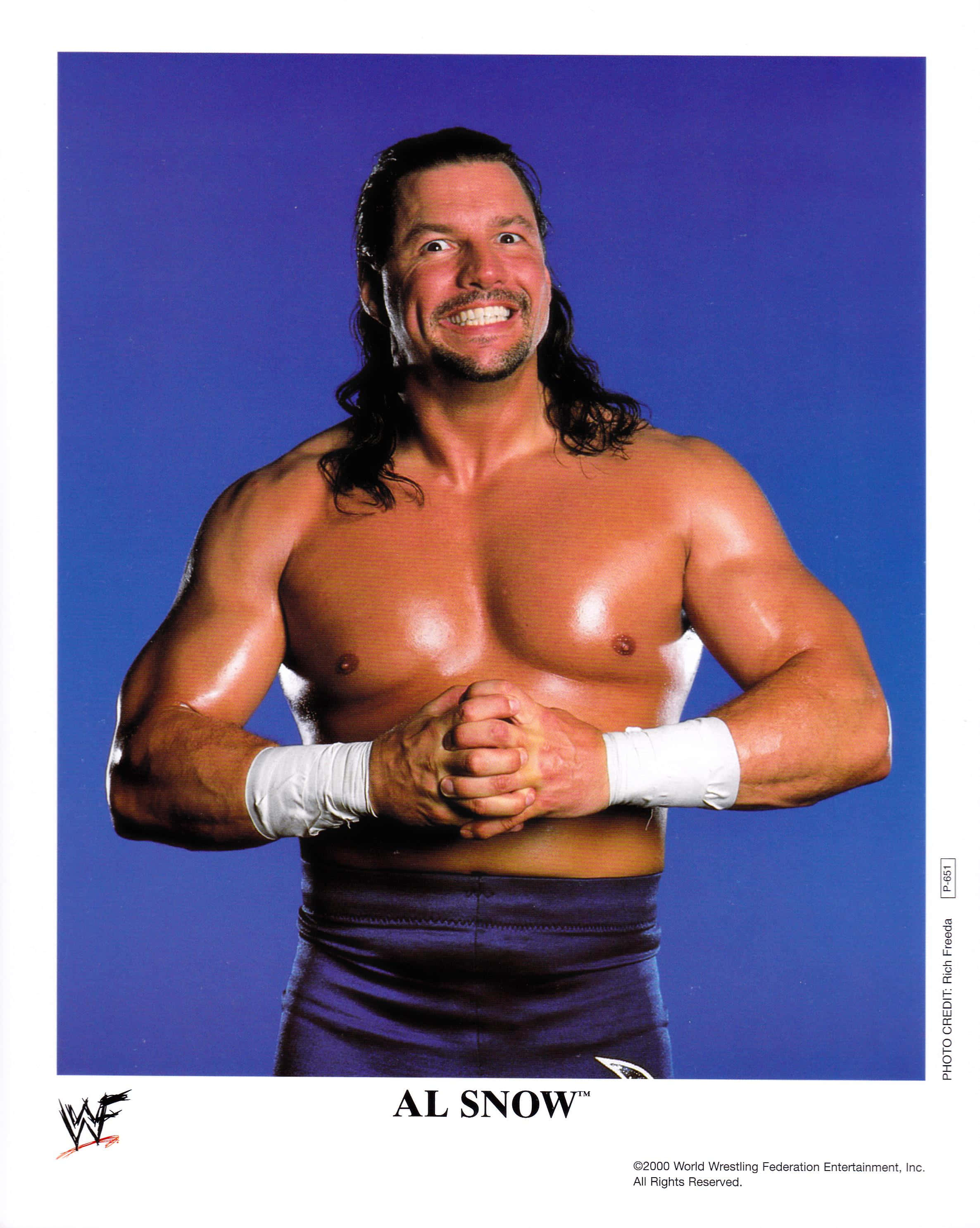 摔角 桌布 壁紙 — 肌肉發達的摔角手 Al Snow 雙手合十，在純藍色攝影棚背景下自信地咧嘴笑。