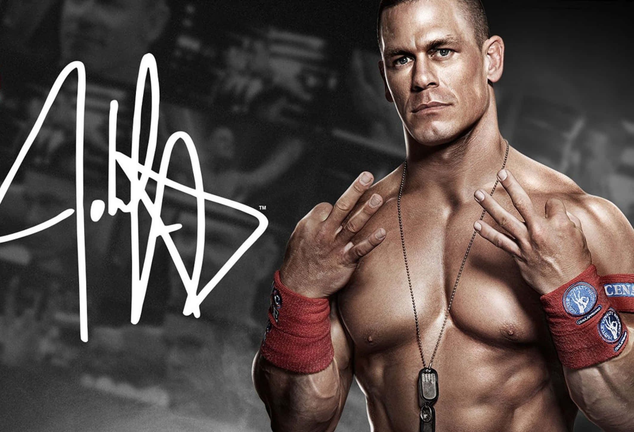 WWE 桌布 壁紙 — 肌肉發達的摔角手 John Cena 在黑暗的健身房背景下，自信地擺出標誌性的手勢。