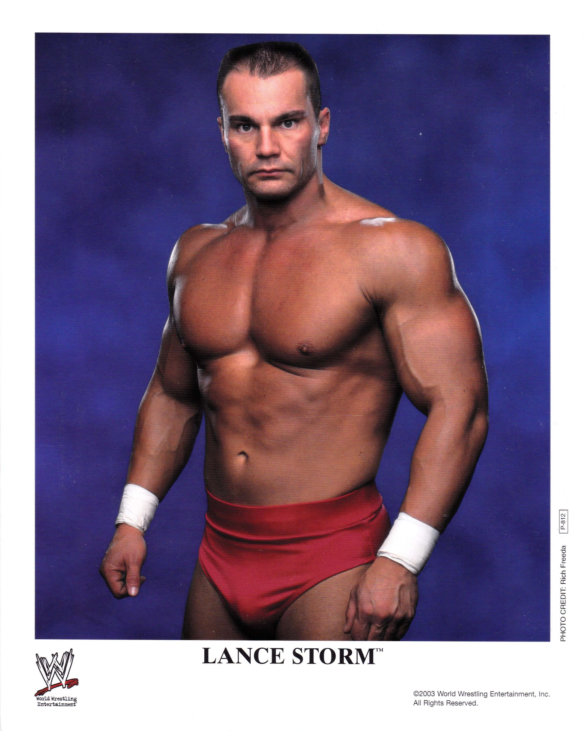 Canadian 桌布 壁紙 — 肌肉發達的摔角手 Lance Storm 在深藍色攝影棚背景下，赤裸上身，穿著紅色三角褲擺姿勢。
