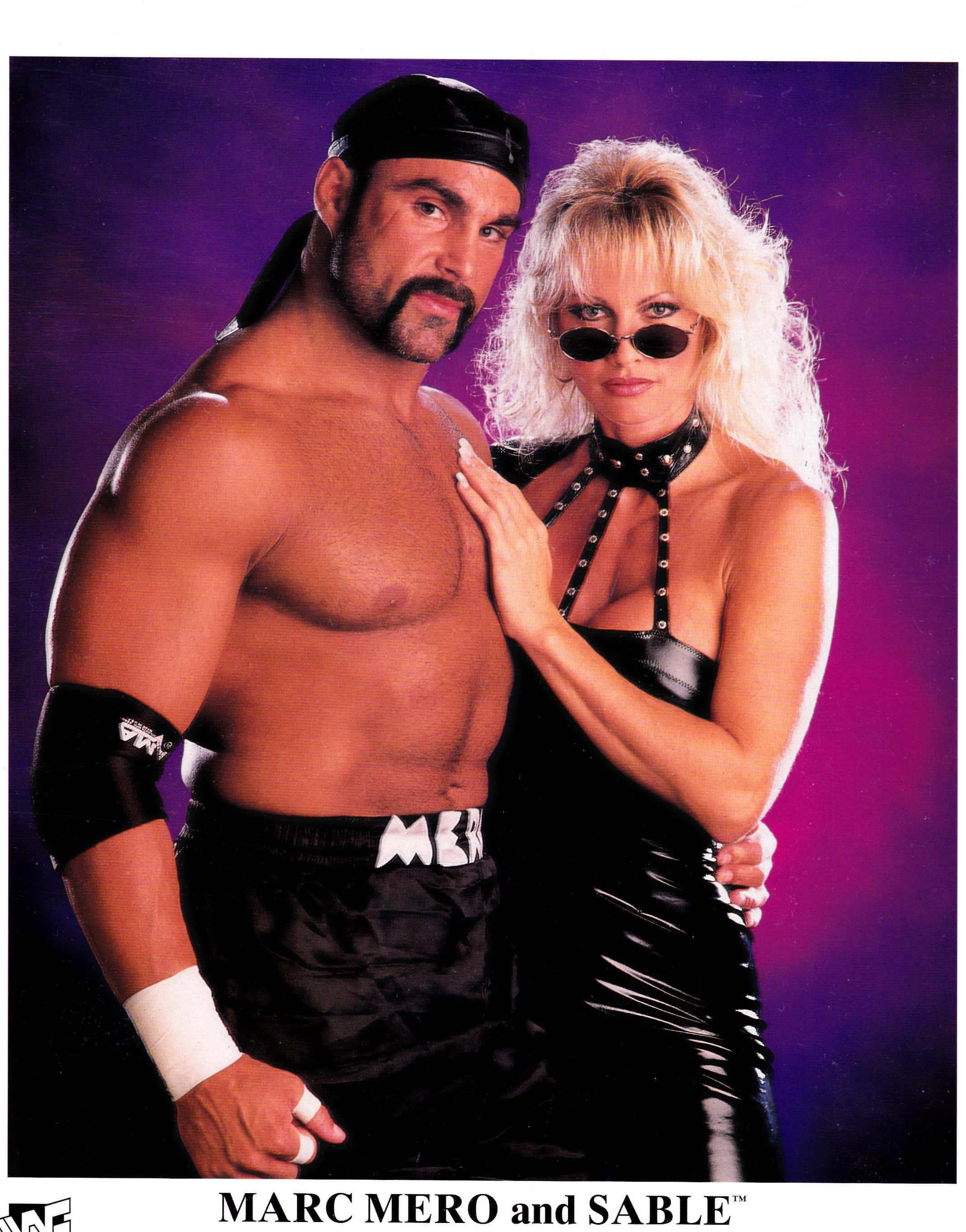 激勵 桌布 壁紙 — 肌肉發達的摔角手 Marc Mero 和金髮摔角手 Sable 在充滿活力的紫色攝影棚背景前自信地擺姿勢。
