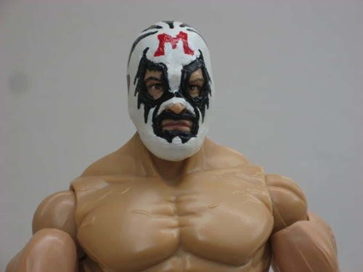 Mask 桌布 壁紙 — 肌肉發達的摔角手動作人偶特寫，戴著白色面具，上面有紅色「M」和黑色部落圖案。