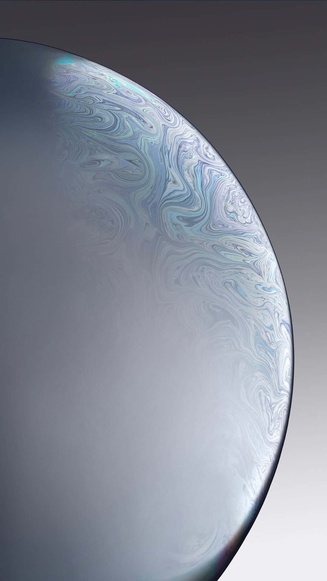 Silver Aesthetic iPhone 桌布 壁紙 — 肥皂泡虹彩表面的特寫，在柔和的灰色漸變背景上呈現藍色、白色和銀色的漩渦圖案。