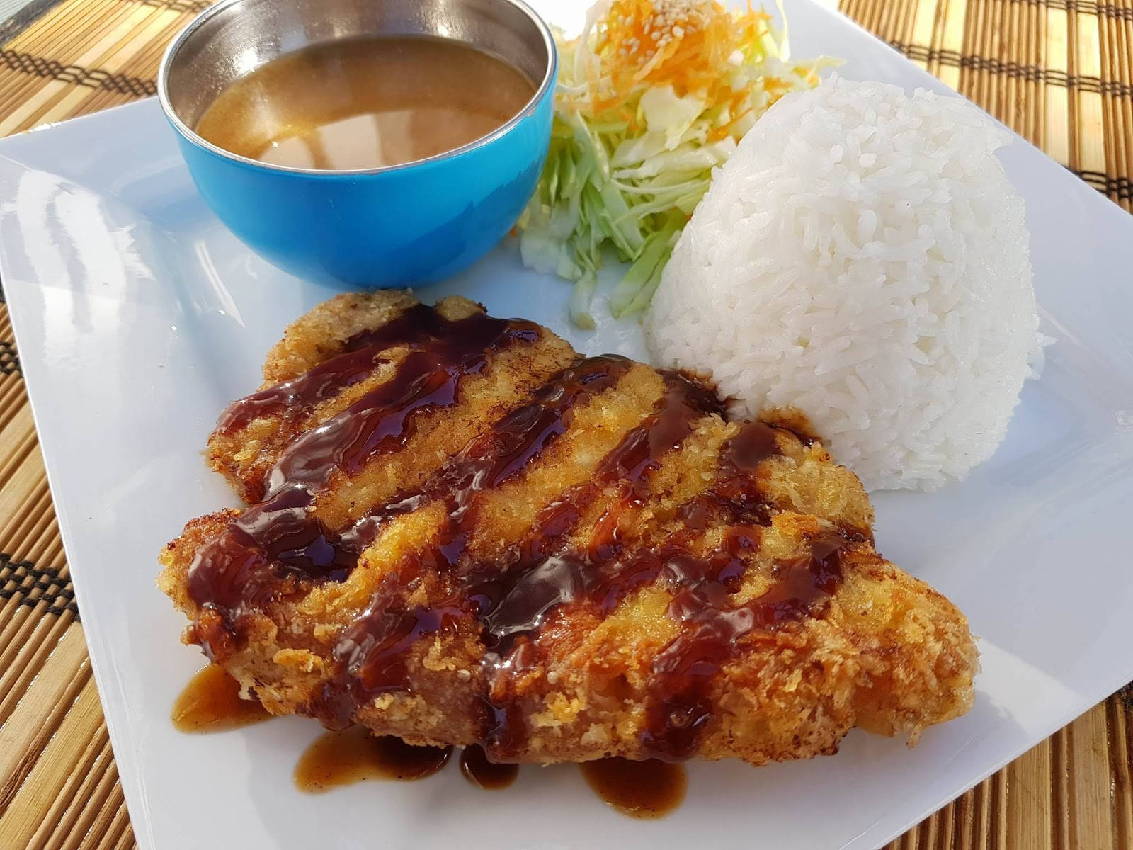 Food Photography 桌布 壁紙 — 脆皮炸雞配深色醬汁，旁邊放著一堆白飯和高麗菜絲，放在白色盤子上。