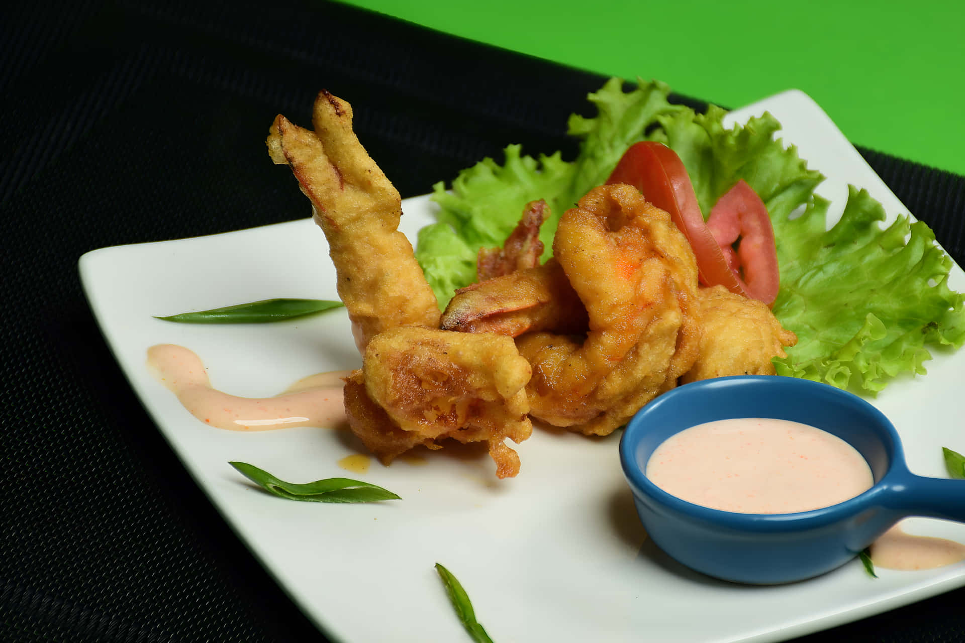 Fried prawn on a plate with white sauce 壁紙 — 脆皮金黃炸蝦，盛載於白色盤子上，配以新鮮生菜、番茄片和一個藍色杯的粉紅色蘸醬。