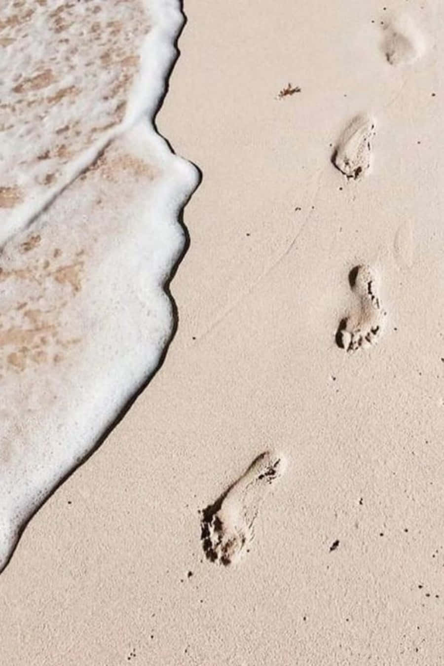 sand 桌布 壁紙 — 腳印穿過濕沙，溫柔的海浪在它們旁邊翻滾。