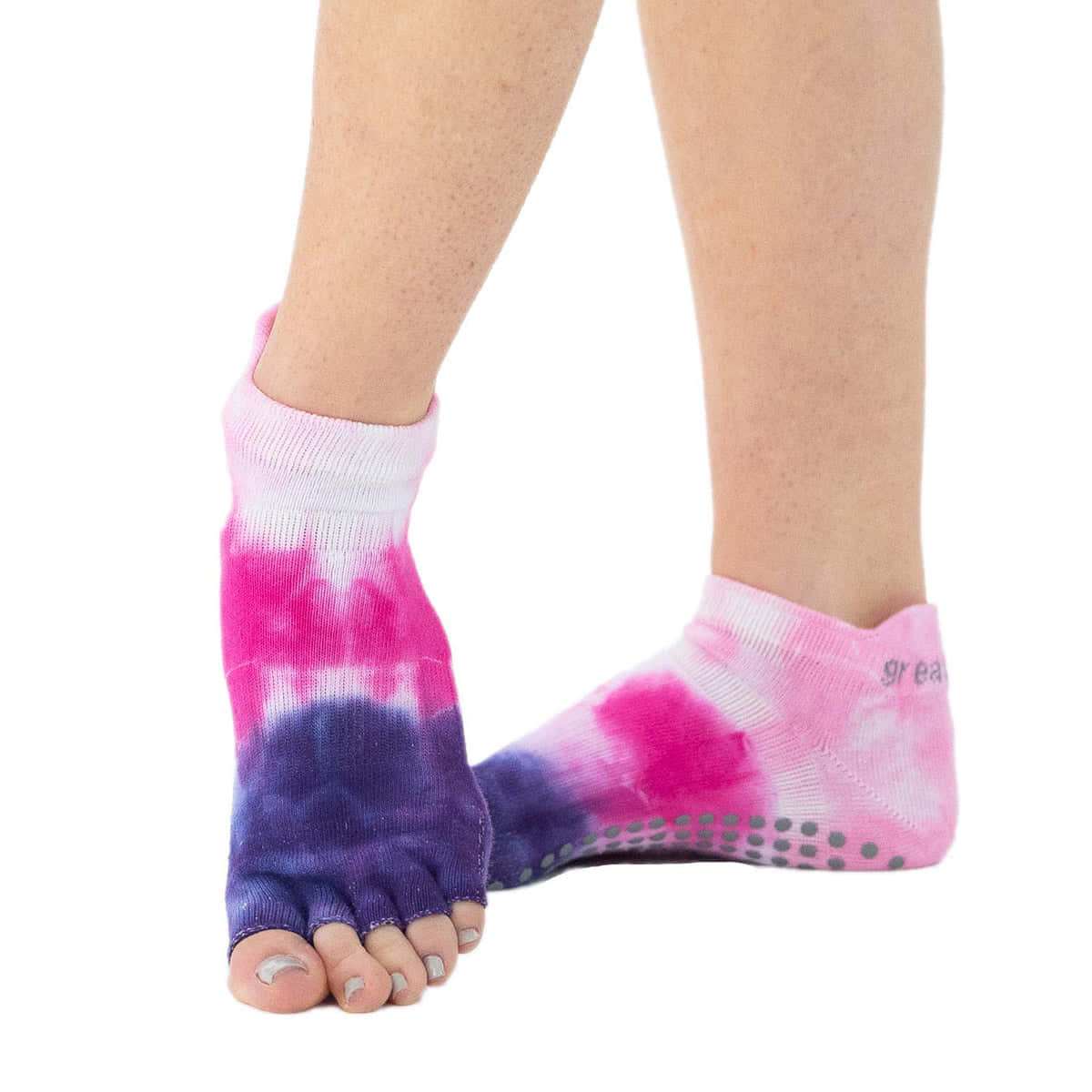 Purple Socks 桌布 壁紙 — 腳部特寫，穿著鮮豔粉紅和紫色紮染趾襪，帶灰色防滑點，背景為白色。