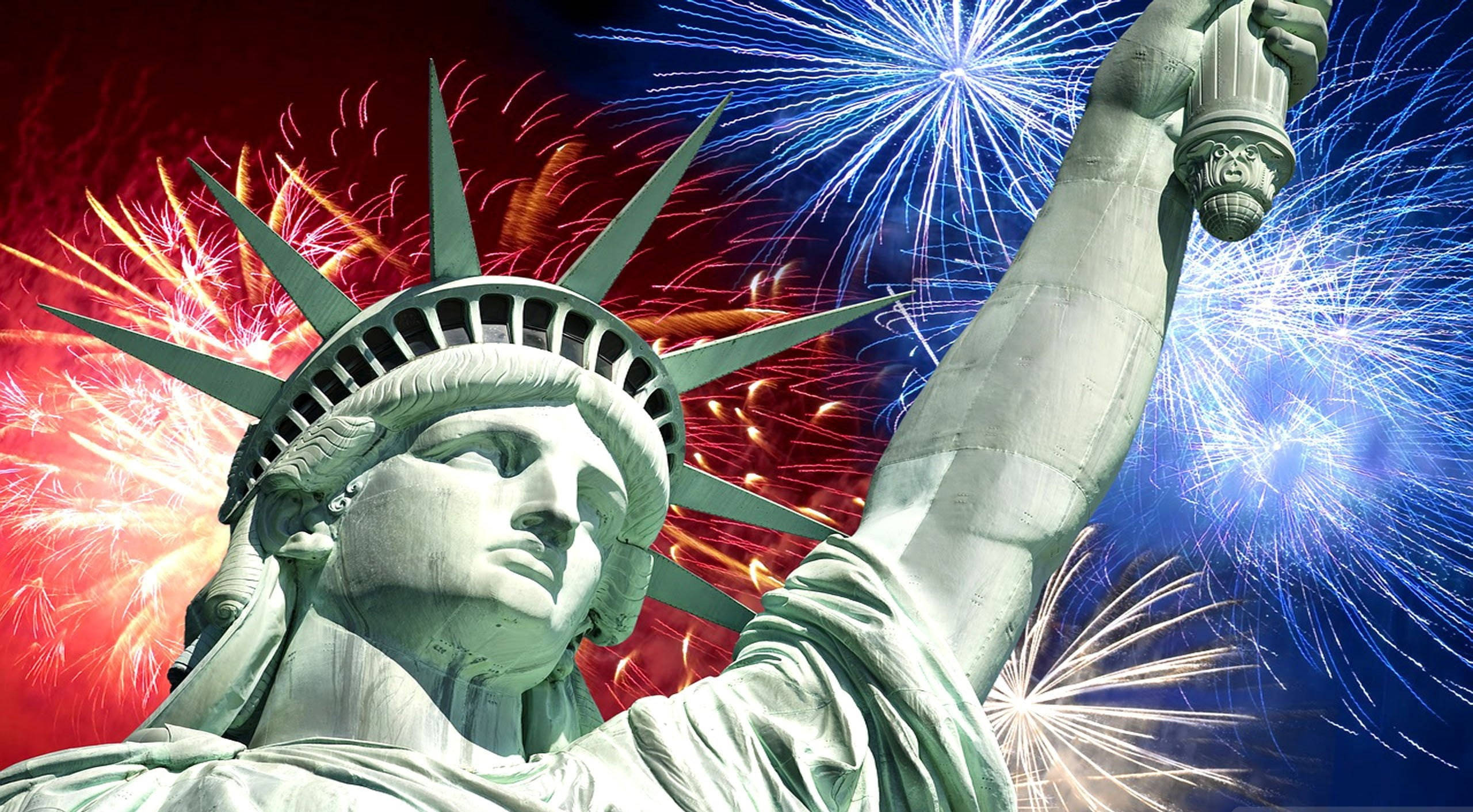 Independence 桌布 壁紙 — 自由女神像在充滿活力的天空中高高聳立，天空爆發出紅色、白色和藍色的煙火。